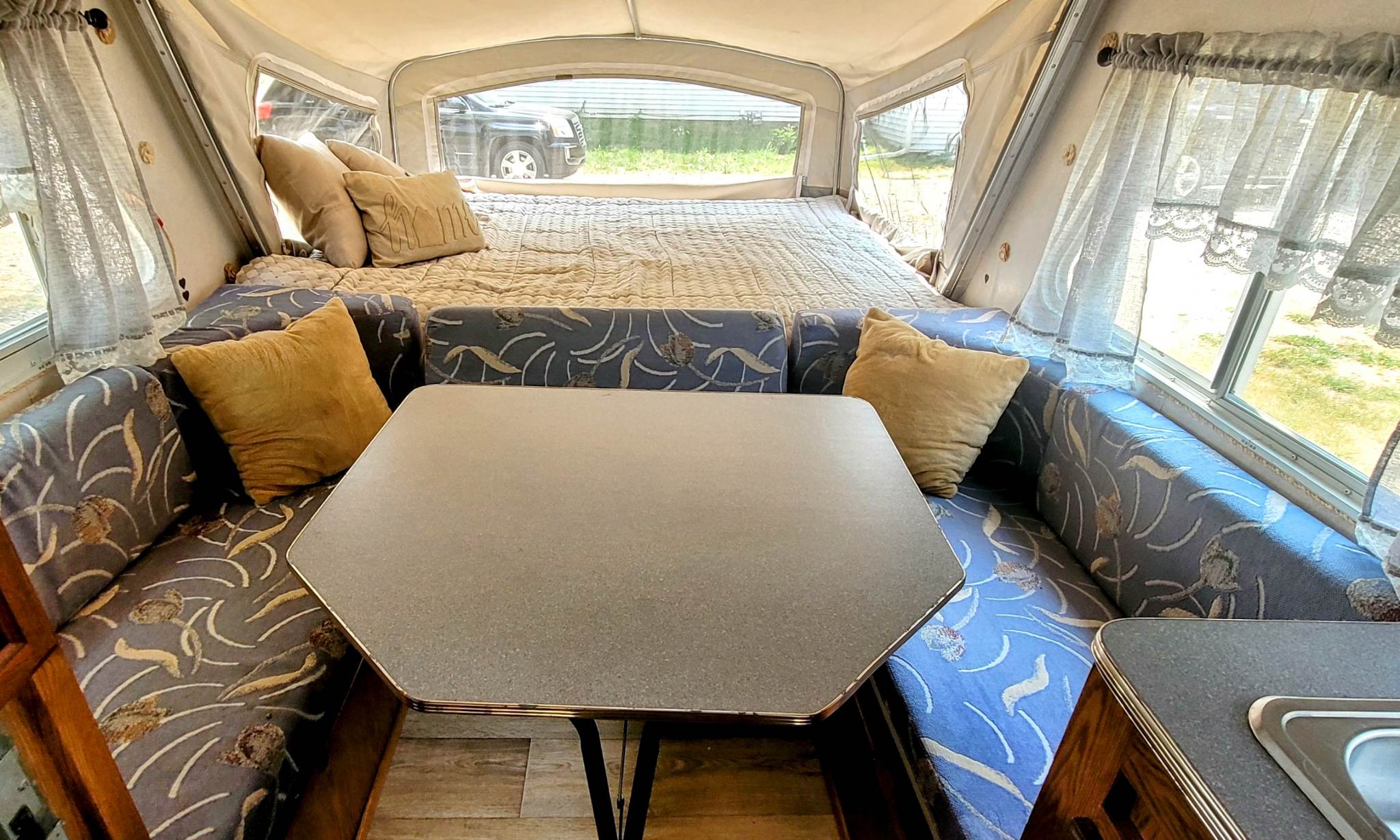 Pop-up RV rental interior: Features a cozy bed, comfortable dinette seating, and bright windows.. Other Other 1998