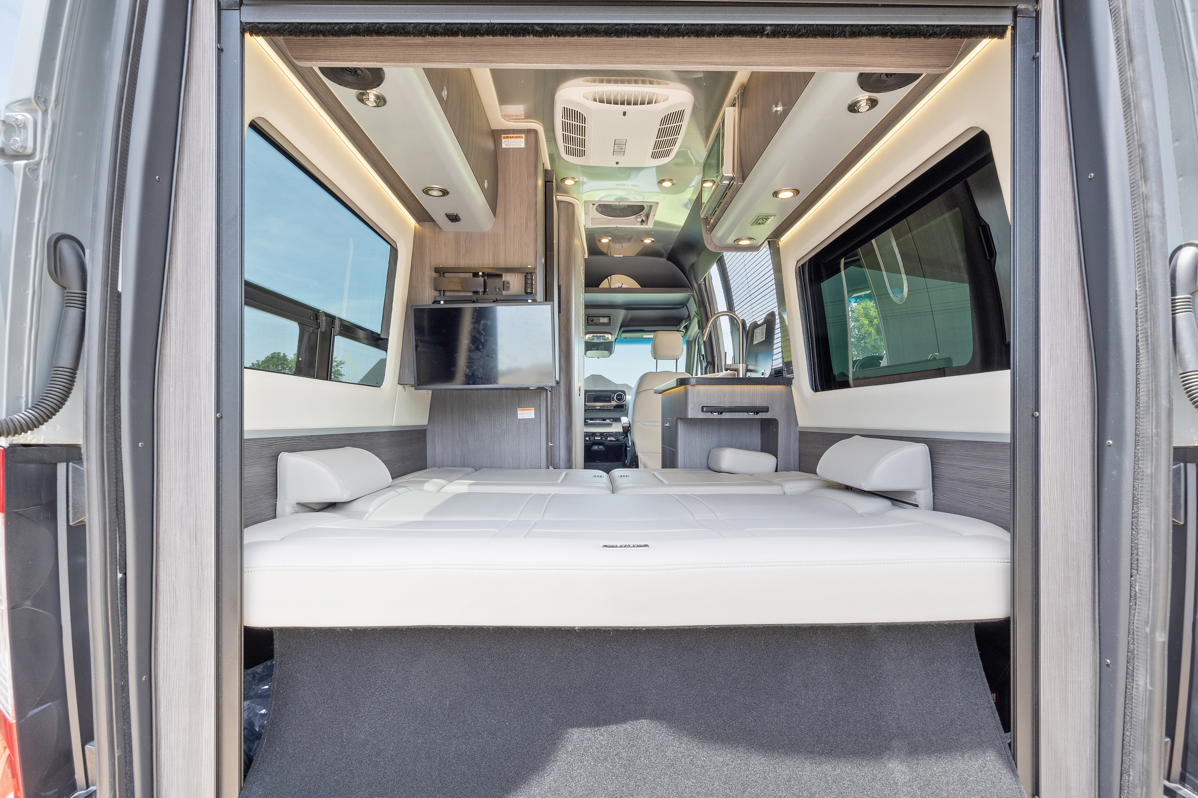 Step inside this modern RV rental! Features a comfortable convertible bed, smart TV, and compact kitchenette.. Airstream Interstate 2023