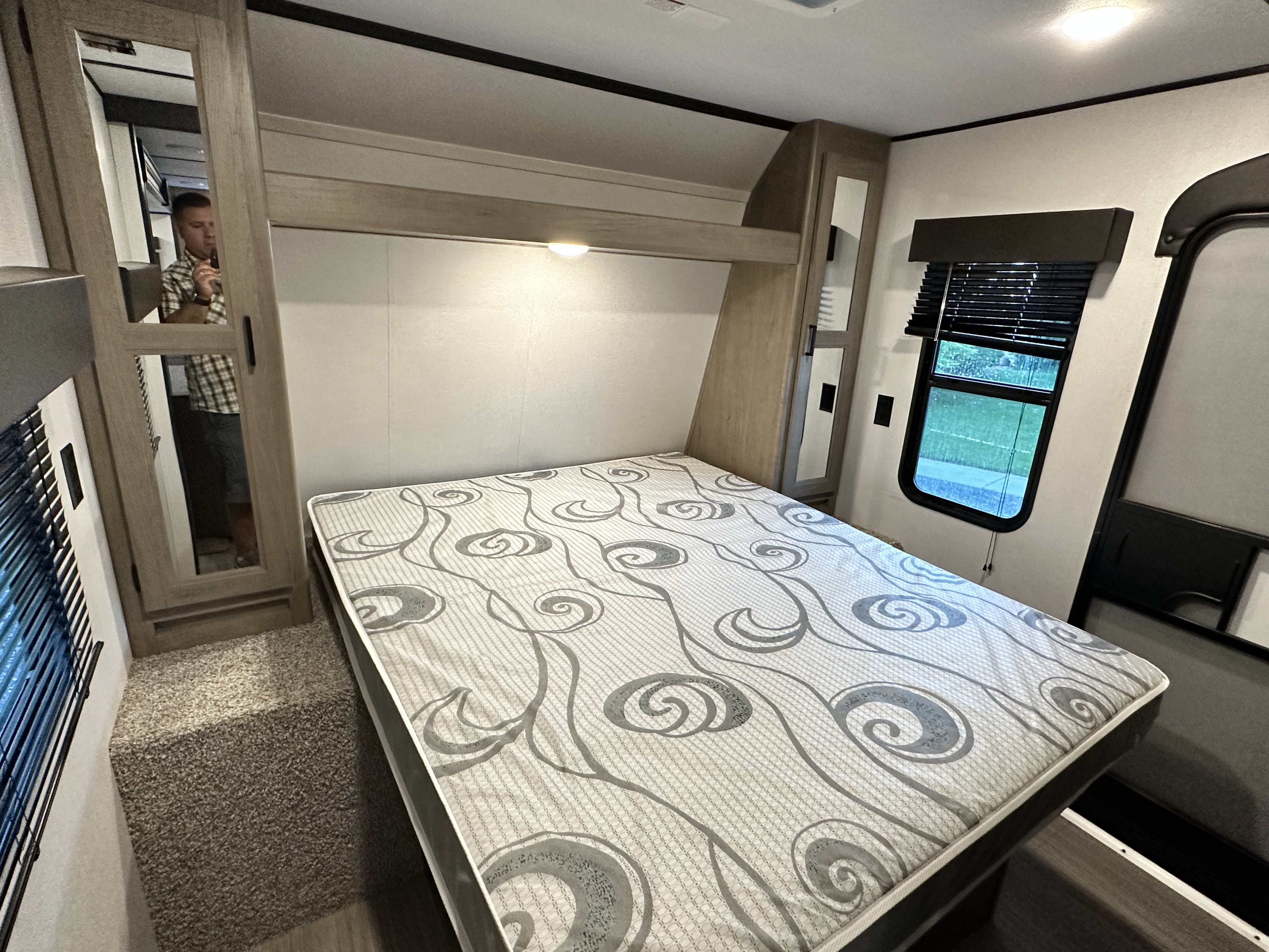 Explore this RV rental's cozy bedroom with a patterned mattress, built-in storage, and window views.. Keystone Hideout 2020