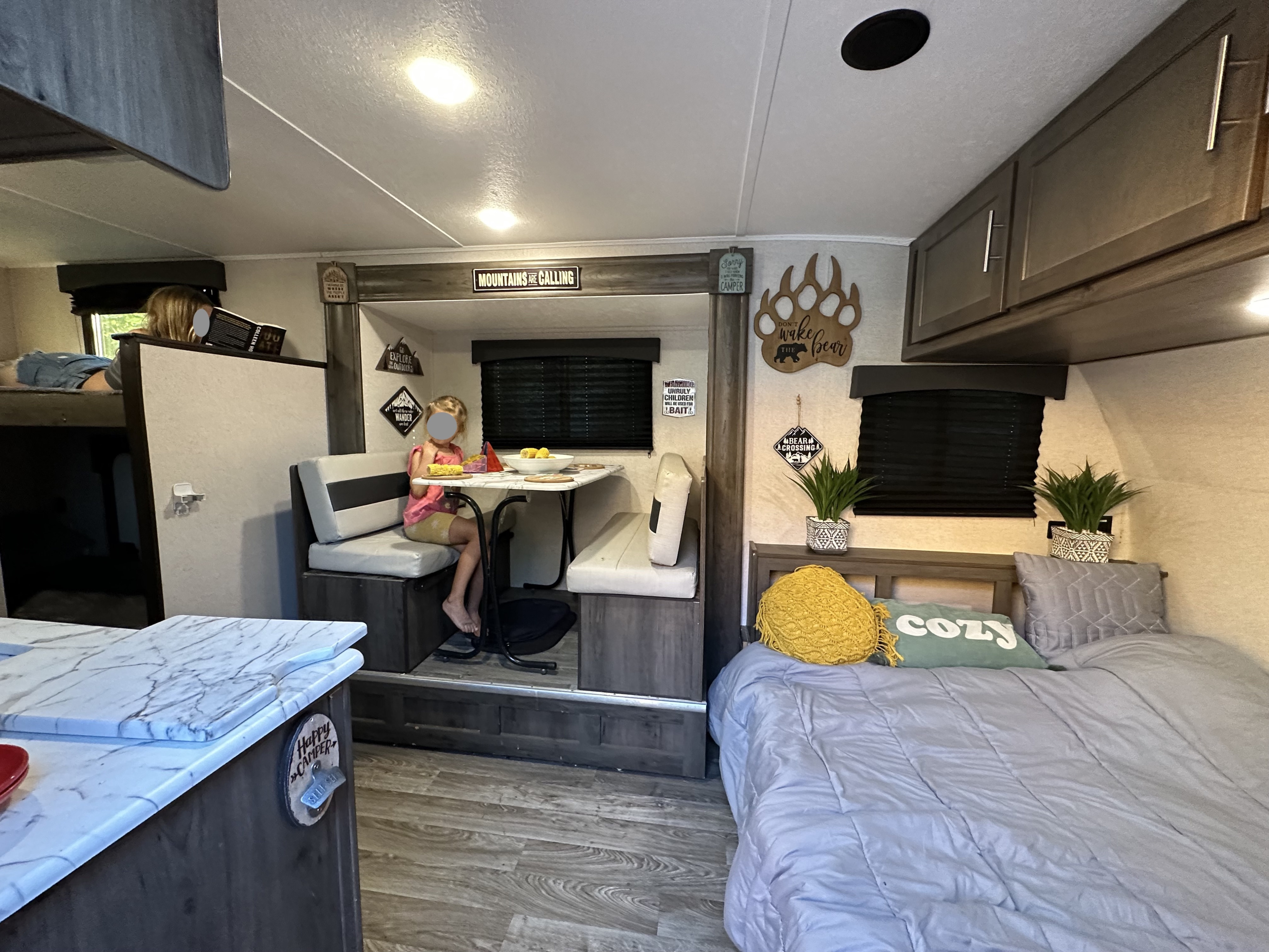 Cozy RV rental interior with a child at the dinette, another reading in a bunk bed, and a comfortable main bed.. Clipper Clipper Trailer 2020