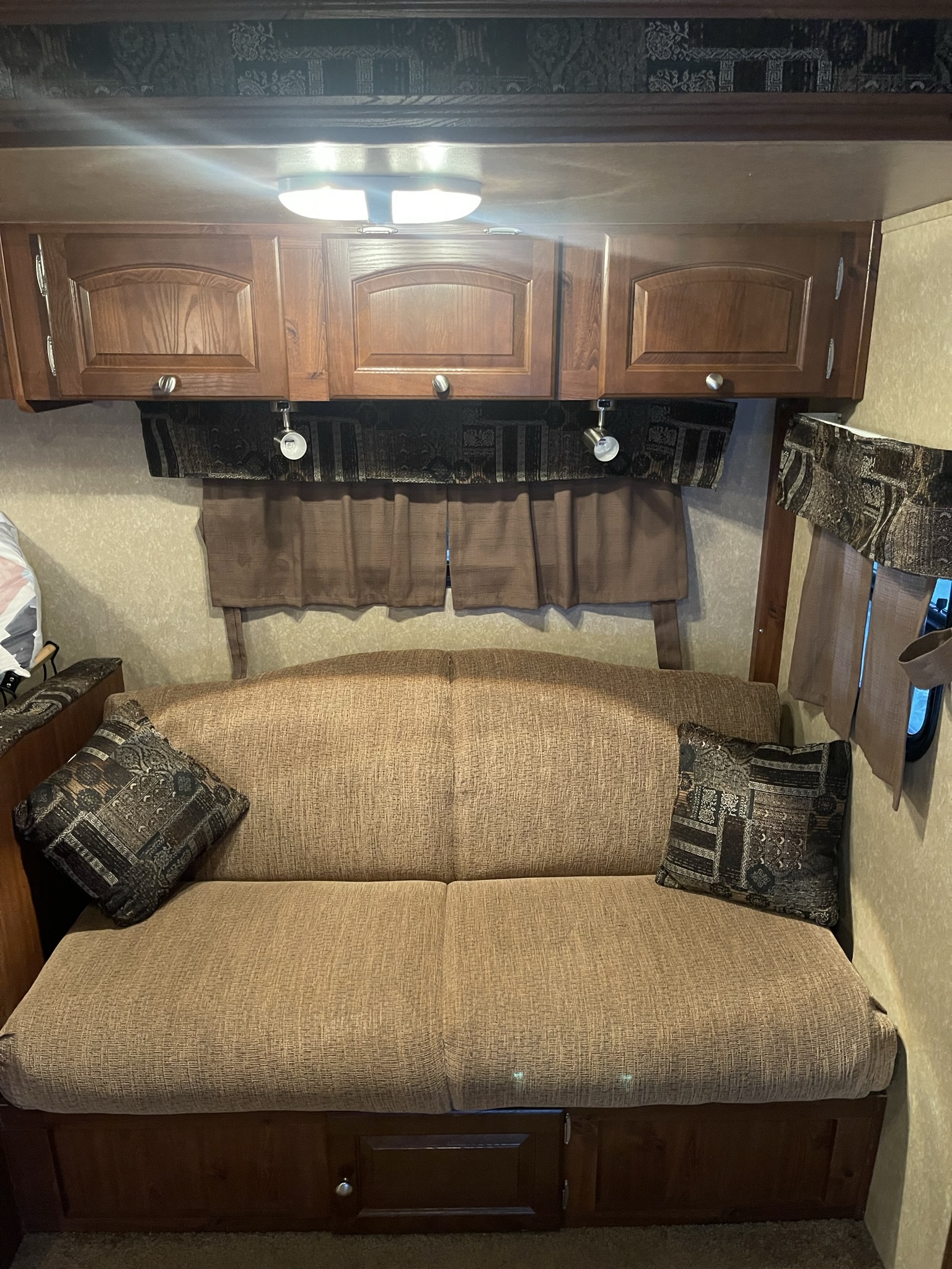 Cozy RV rental interior with a comfortable sofa, overhead cabinets, and ambient lighting, perfect for relaxing.. Forest River Rockwood Roo 2011