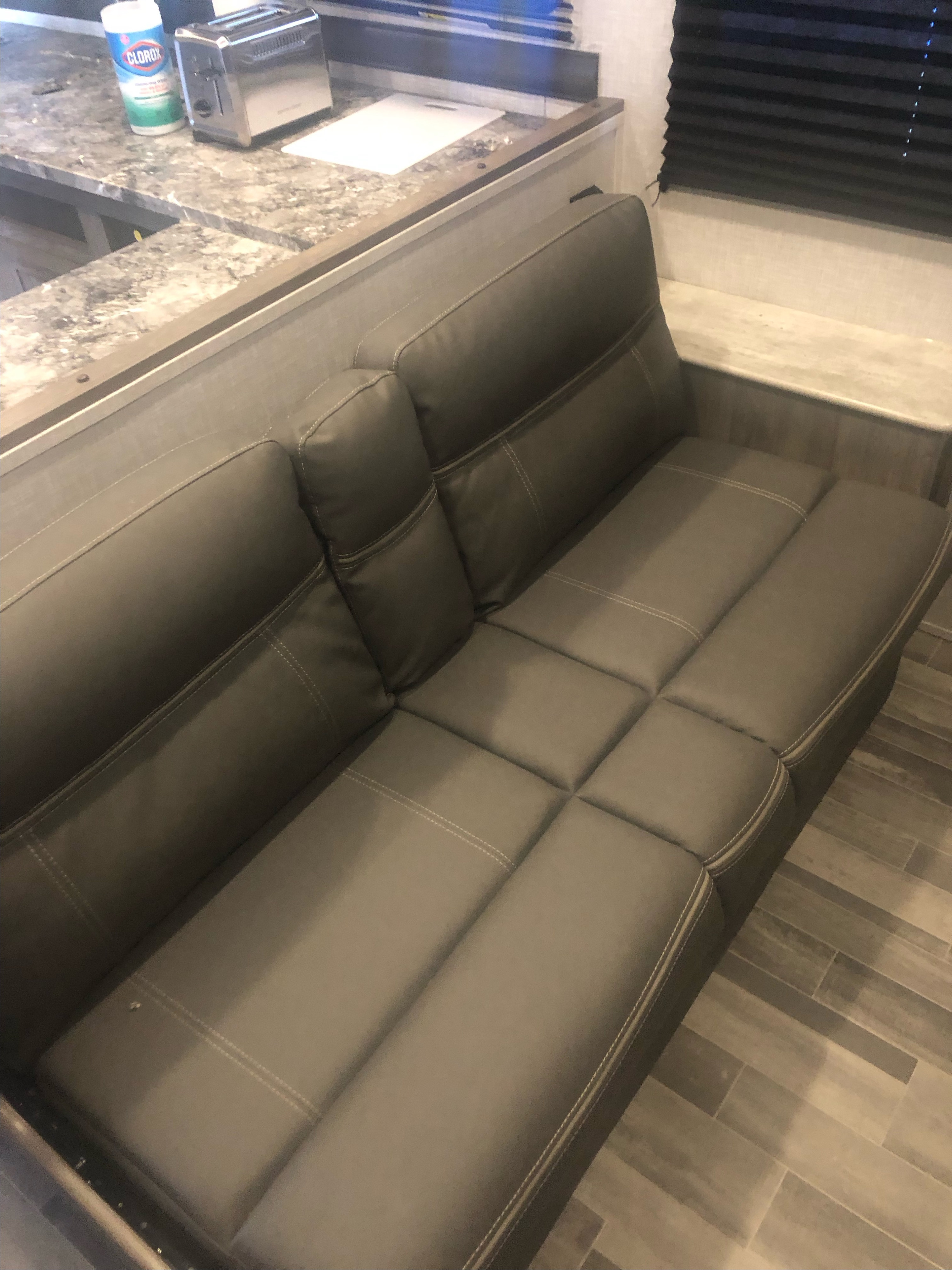 Compact RV rental with comfy grey sofa, integrated kitchen counter, toaster, and wipes. Ready for your adventure.. Crossroads RV Zinger Lite 2022