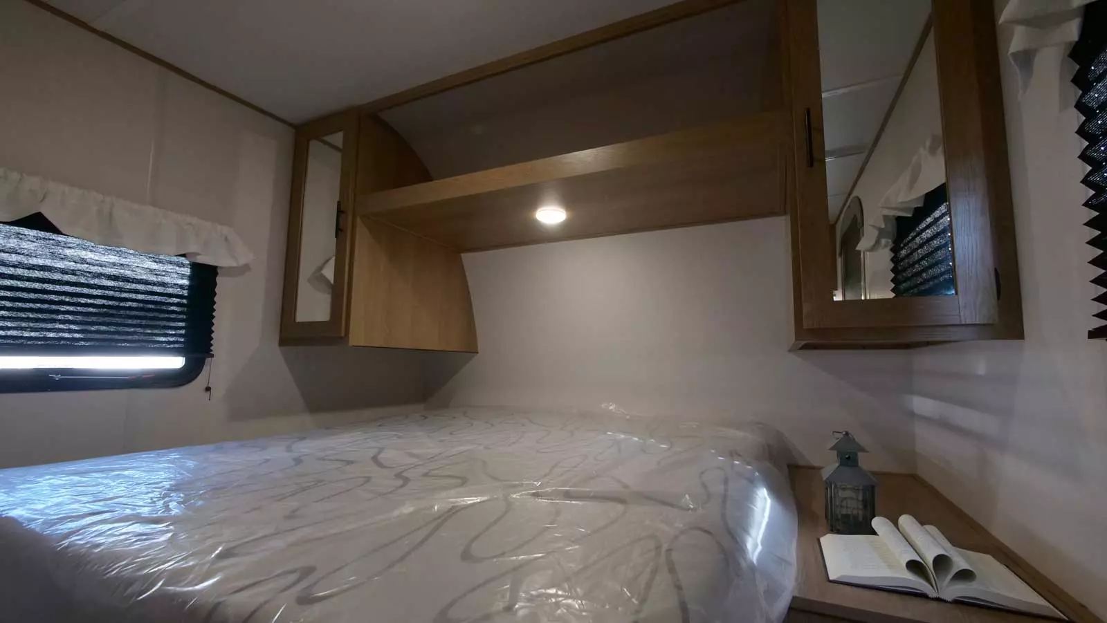Cozy RV rental bedroom with fresh bed, overhead storage, and window blinds. Perfect for your next adventure!. Avenger LT 2022