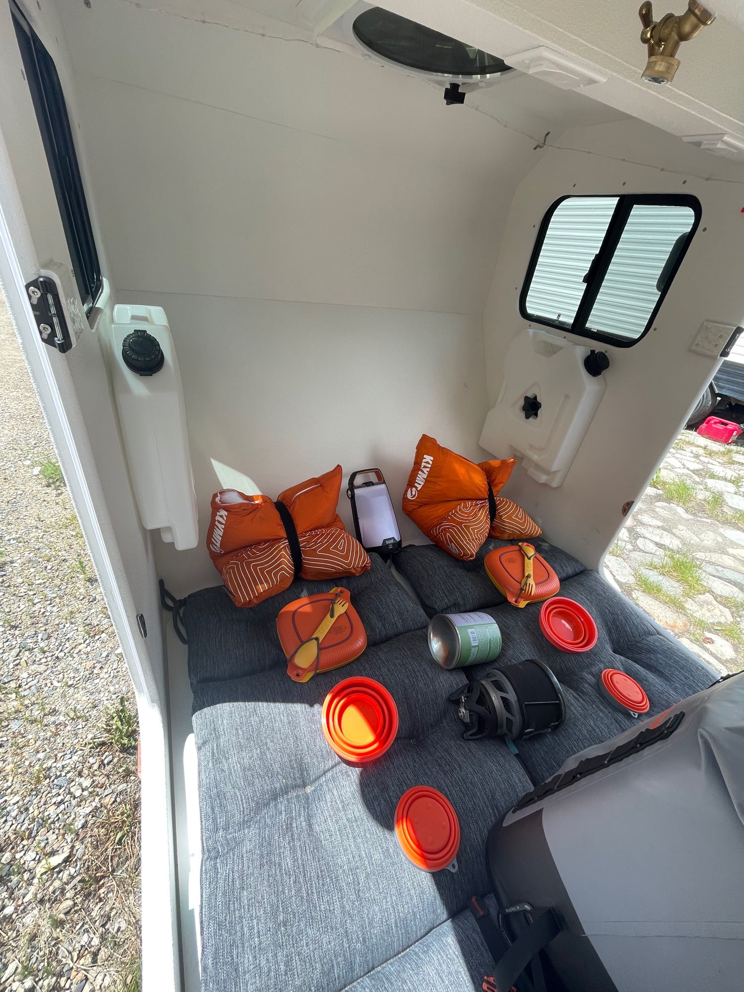 Cozy rv rental interior with a bed setup, water tanks, and essential camping gear for journeys.. Other Other 2022