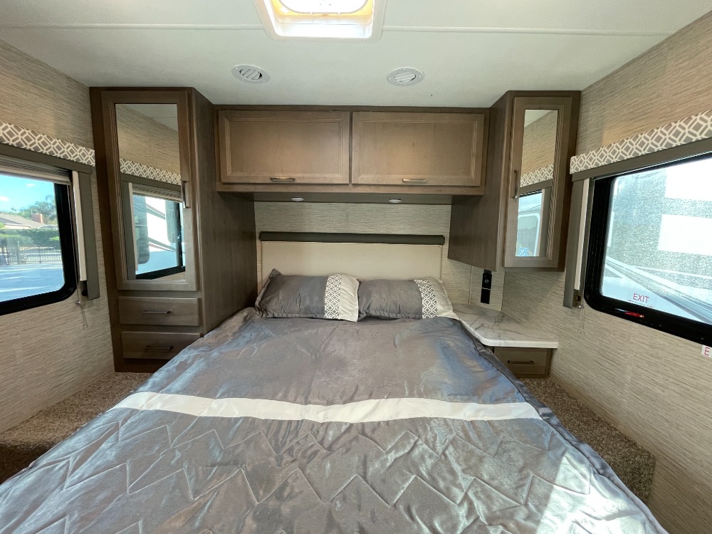 RV rental bedroom: cozy interior with bed, overhead cabinets, and mirrored wardrobes for compact comfort.. Thor Coleman 2023