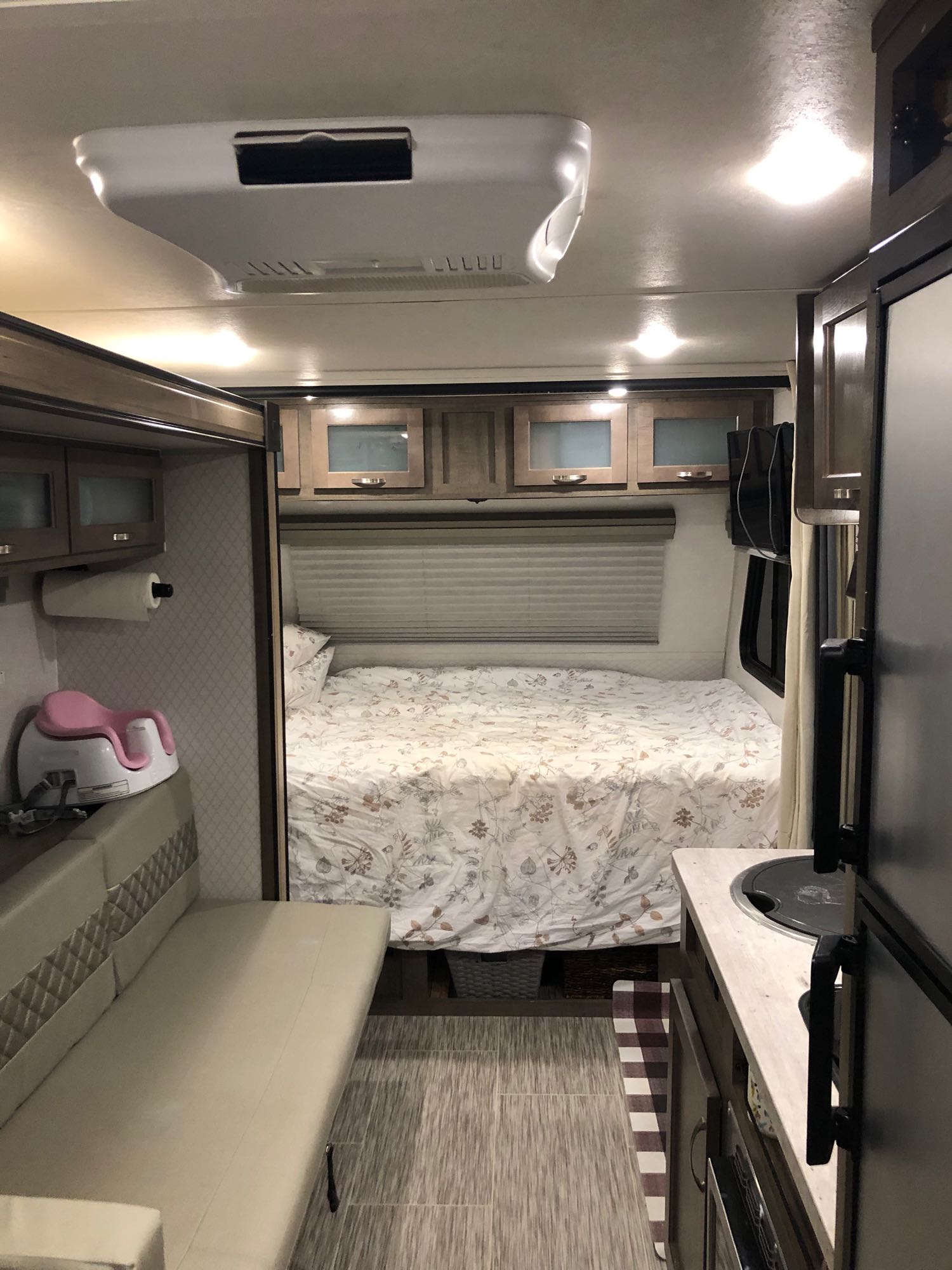 RV rental interior: cozy bed, dinette seating, kitchenette, overhead storage, and ceiling-mounted AC unit.. No Boundaries 19 2020