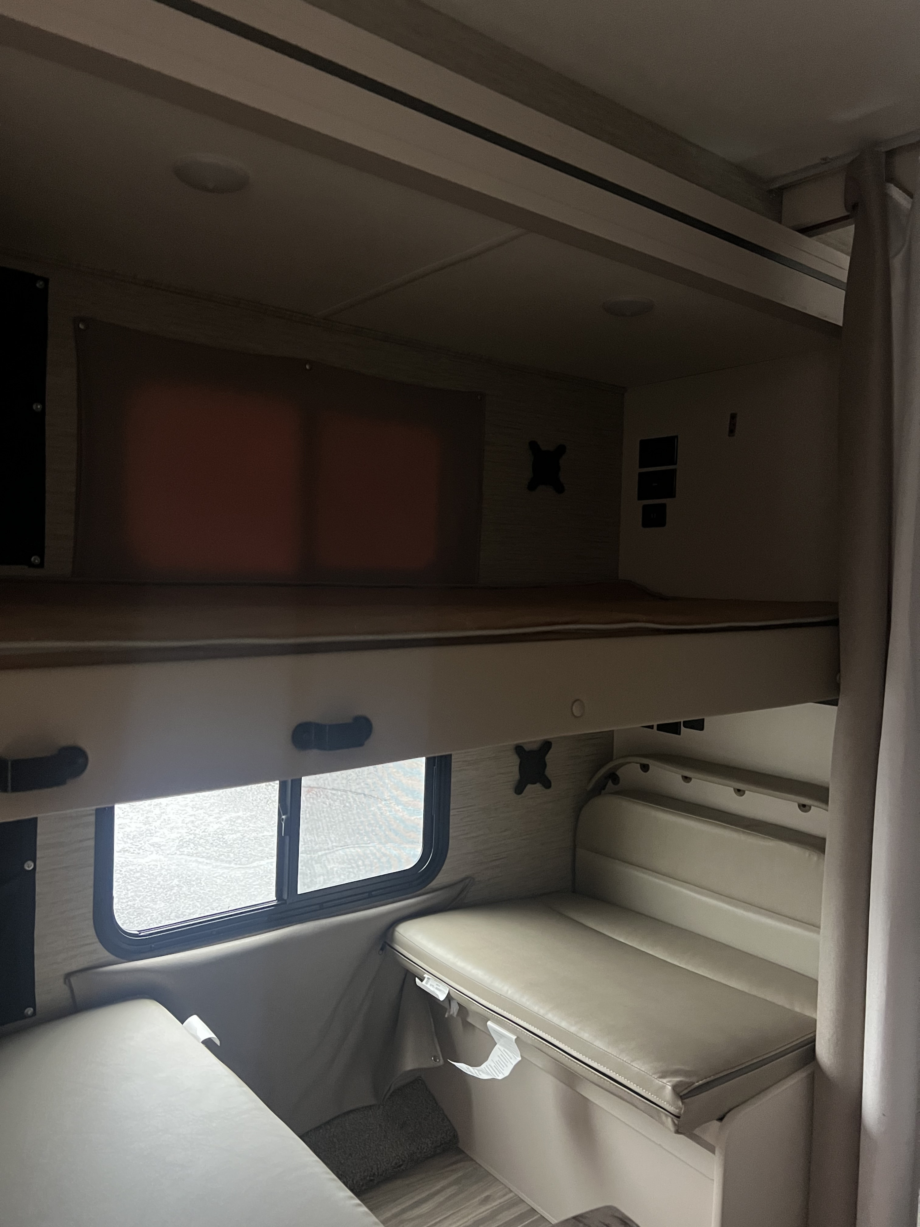Inside an rv rental: dual bunk beds and a convertible dinette offer compact sleeping and dining options for your journey.. Thor Freedom Elite 2023
