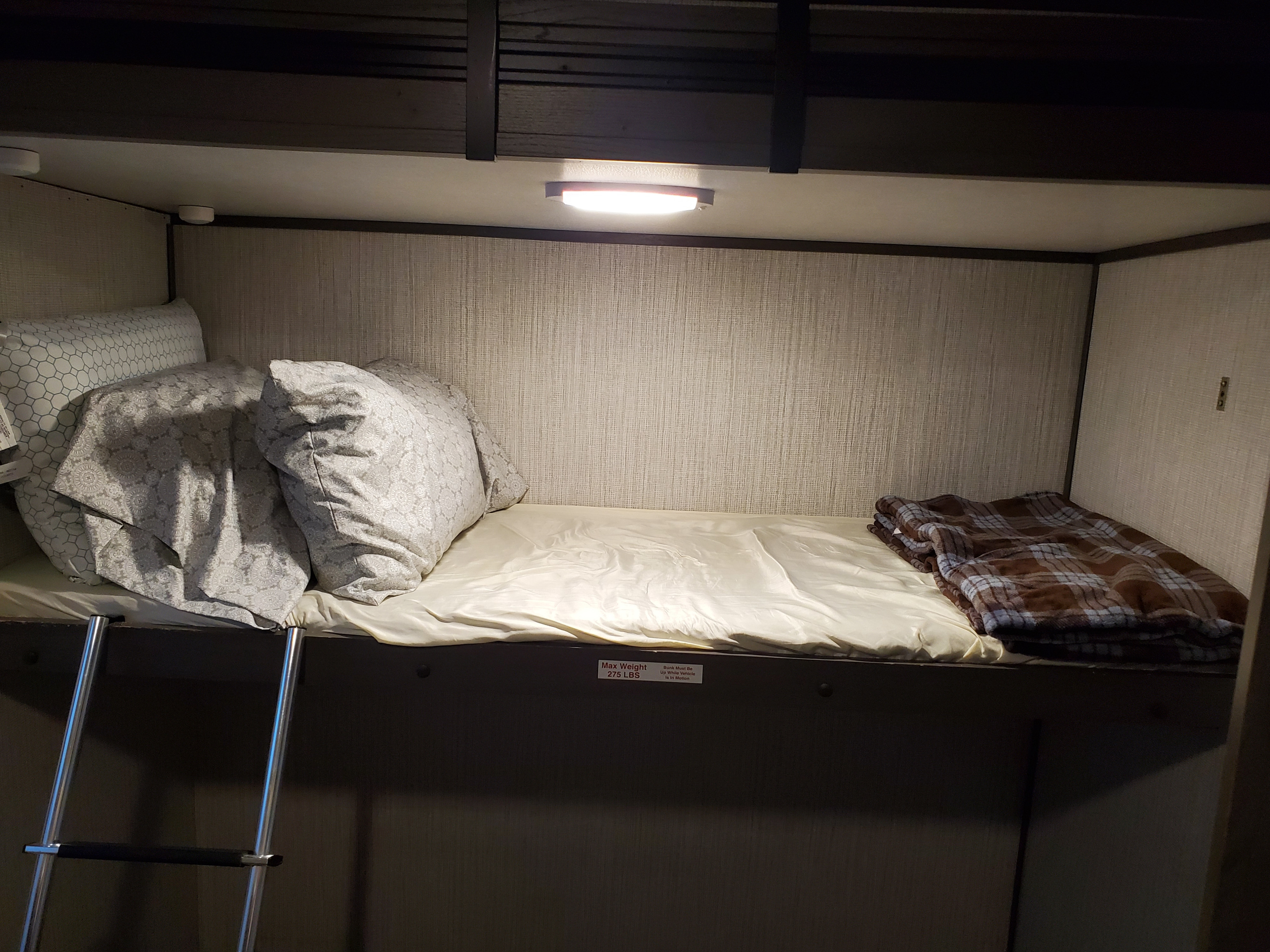 Cozy RV rental bunk bed with ladder, pillows, blankets, and overhead light. Max weight 275 lbs.. Cruiser RV MPG Ultra Lite 2020