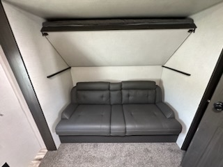 Cleverly designed RV rental interior with a comfortable sofa and a space-saving folded bunk bed.. Sport Trek Touring 2021