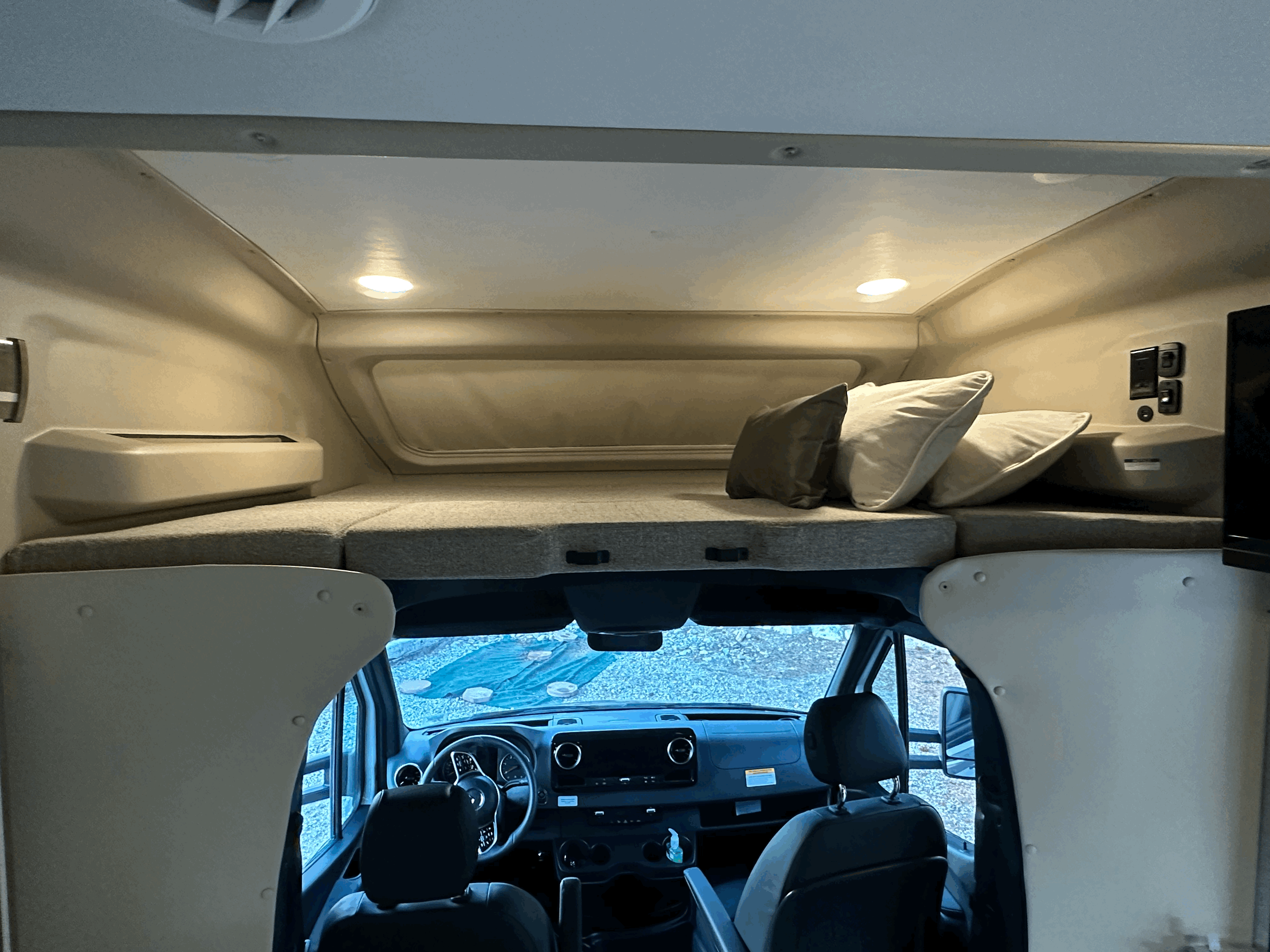 Inside an RV rental, featuring a comfortable over-cab bunk sleeping area above the driver's cabin.. Entegra Coach Qwest 2023