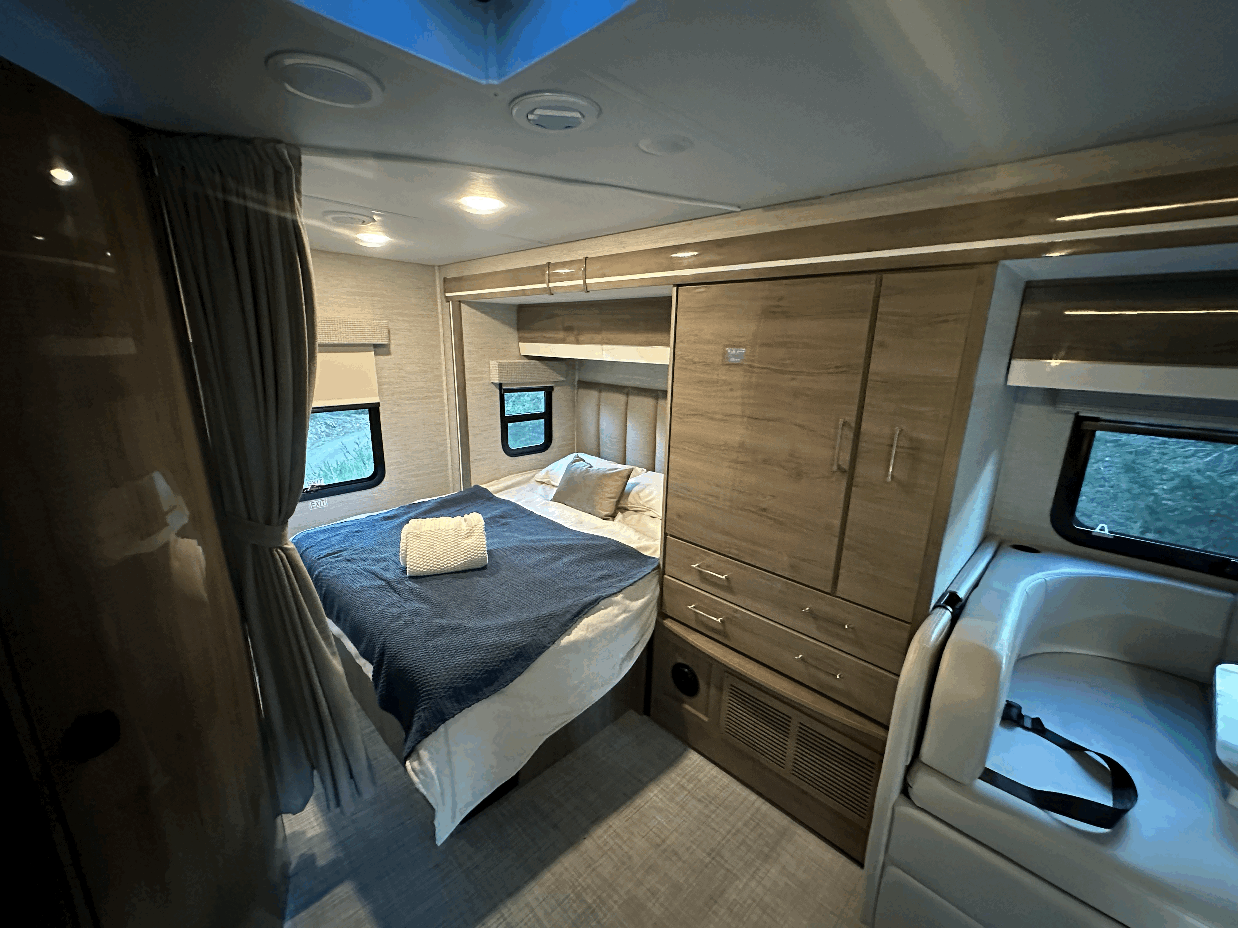 Experience comfort in this RV rental's inviting bedroom, complete with a cozy bed, ample storage, and scenic views.. Entegra Coach Qwest 2023