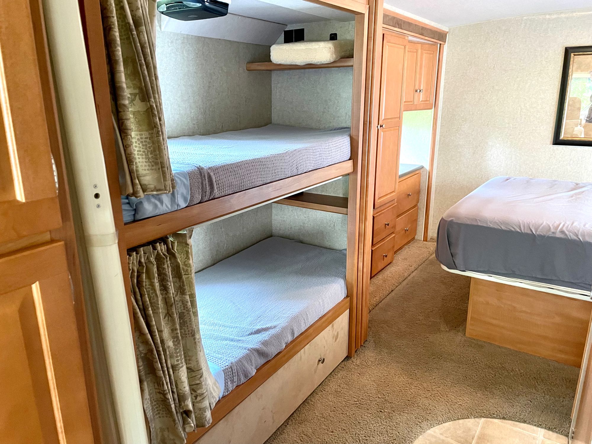 Spacious RV rental bedroom with cozy bunk beds, a master bed, and ample storage cabinetry for a comfortable journey.. Itasca Sunstar 2008