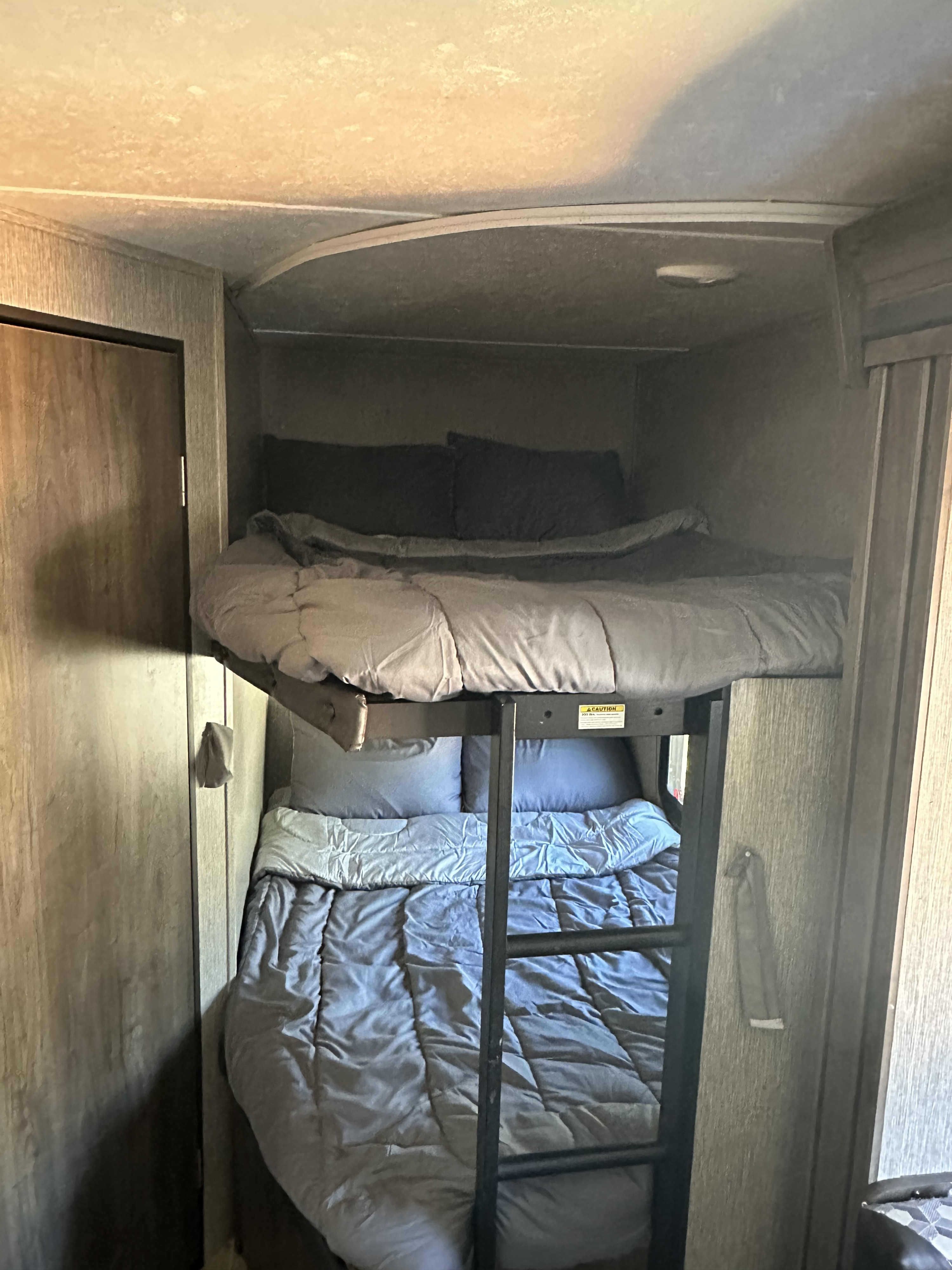 RV rental: Cozy bunk beds with grey bedding and ladder offer a compact sleeping area in this RV.. Dutchmen Coleman Lantern 2020