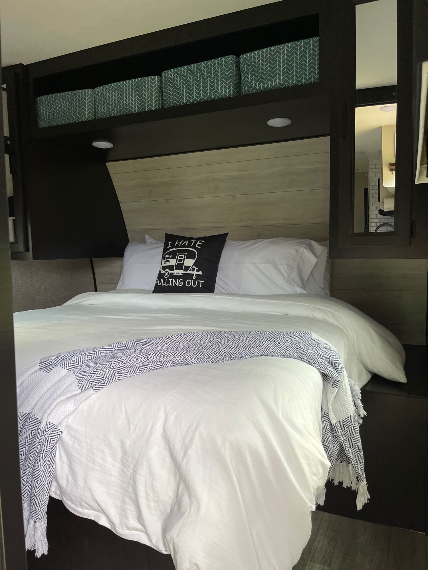 Comfortable RV rental bedroom featuring a neatly made white bed with a fun camper pillow, overhead storage, and modern decor.. Jayco Jayflight 324BDS 2023