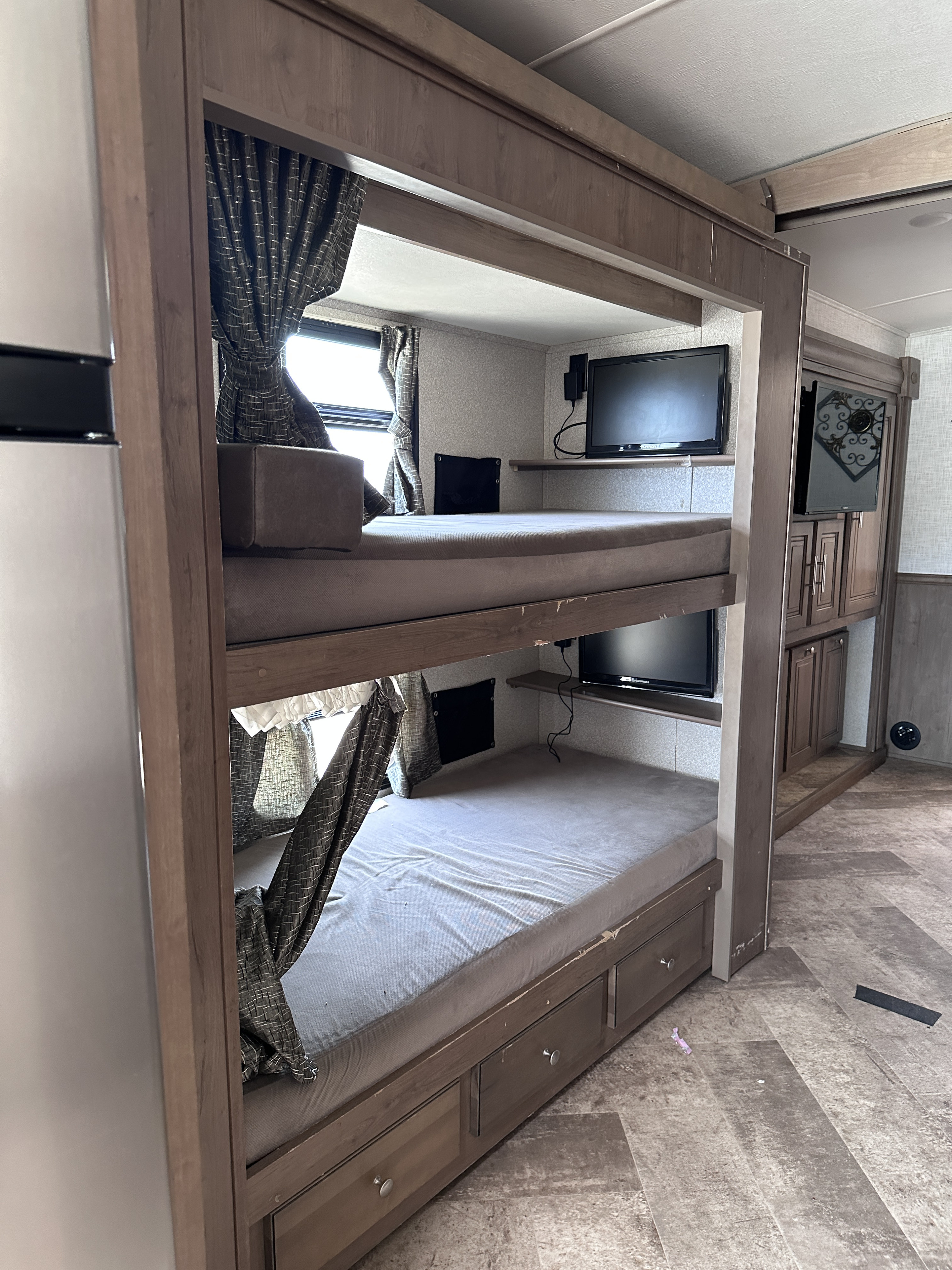 This RV rental interior features practical bunk beds, each with a TV, integrated storage, and window curtains for comfort.. Georgetown GT5 2018
