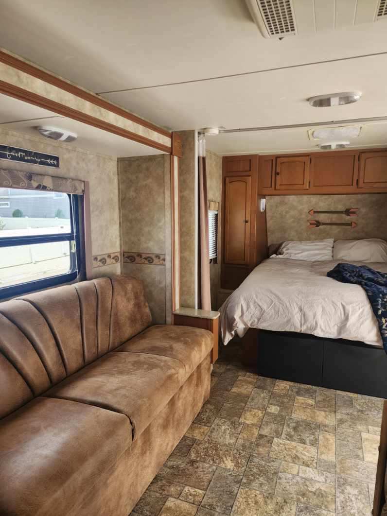 Cozy RV rental interior featuring a comfy sofa, bedroom area with bed, and functional cabinetry, perfect for travel.. Gulf Stream Stream Lite Sport 2011