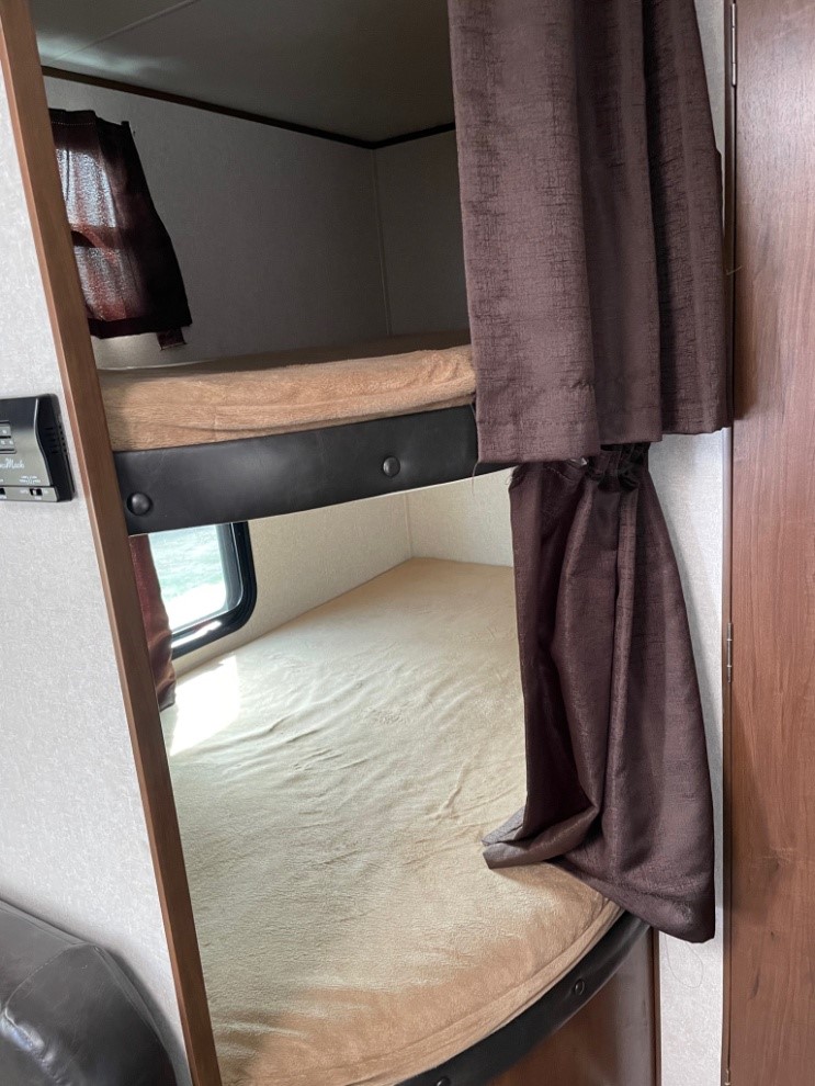Cozy bunk beds in an RV rental, perfect for family travel. Features privacy curtains & windows for comfort.. Jayco Jay Flight 2017