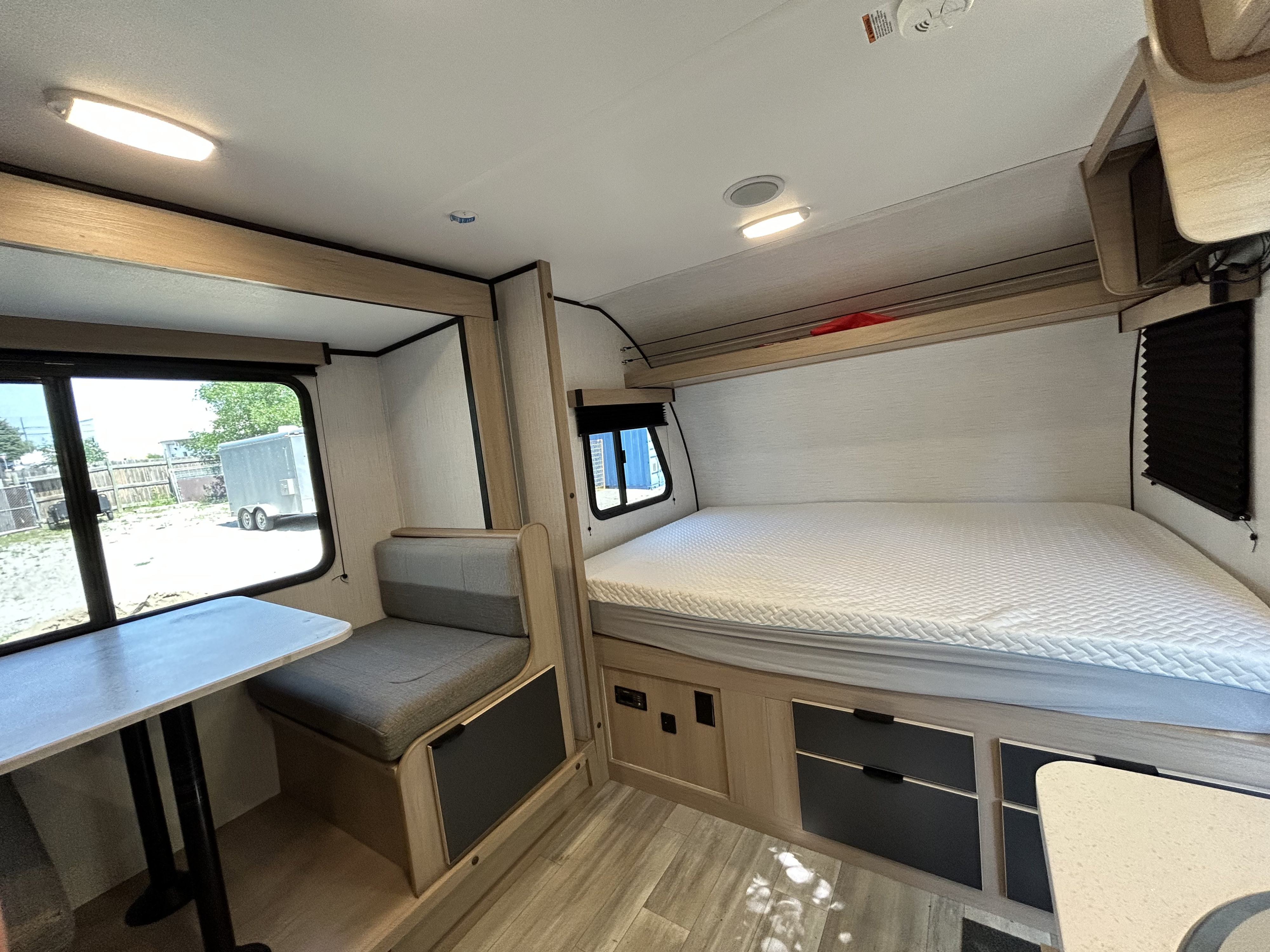 Spacious RV rental interior featuring a comfortable bed, dining area, and bright windows for your next adventure.. Cruiser RV Hitch 2022