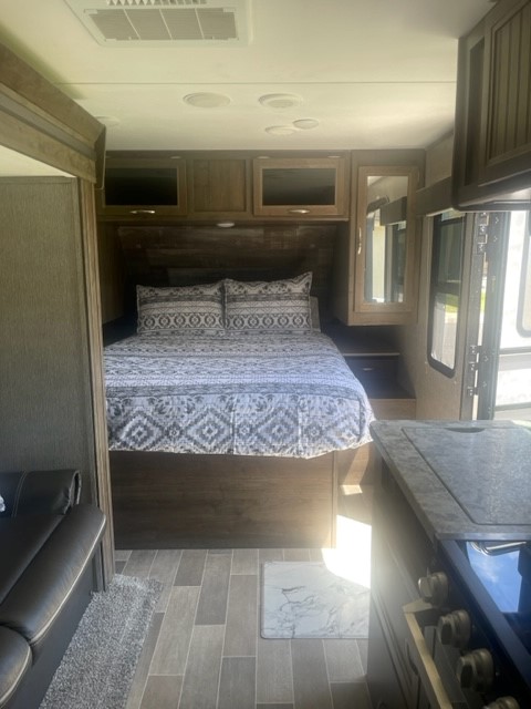 Spacious RV rental interior featuring a cozy bedroom, kitchen, and living area. Perfect for your next adventure.. Dutchmen Coleman Light 2019