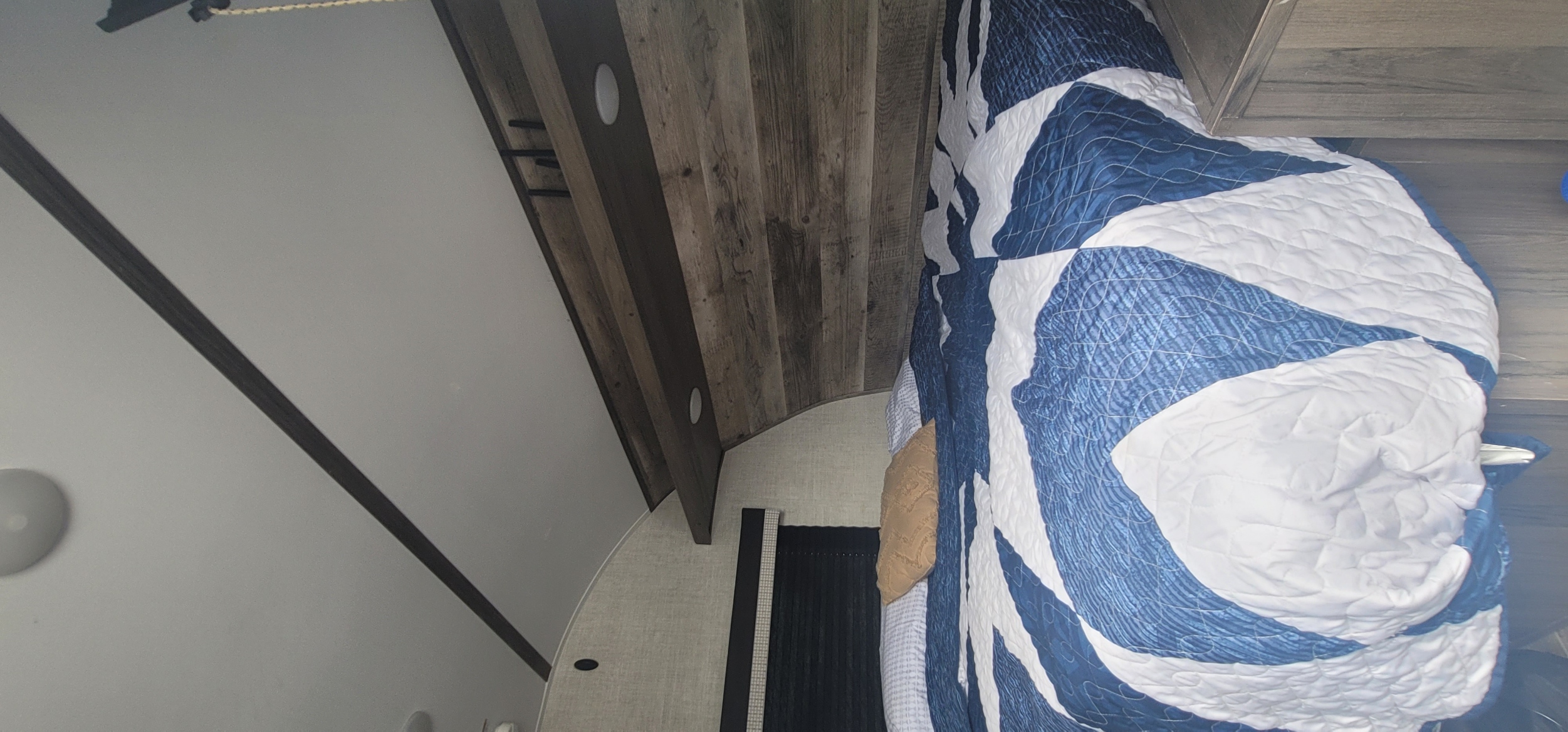 Queen bed with overhead and under storage. Bed lifts up for easy storage. Side nightstand and clothing cabinet with wall mounted TV. Gulf Stream Enlighten 2021