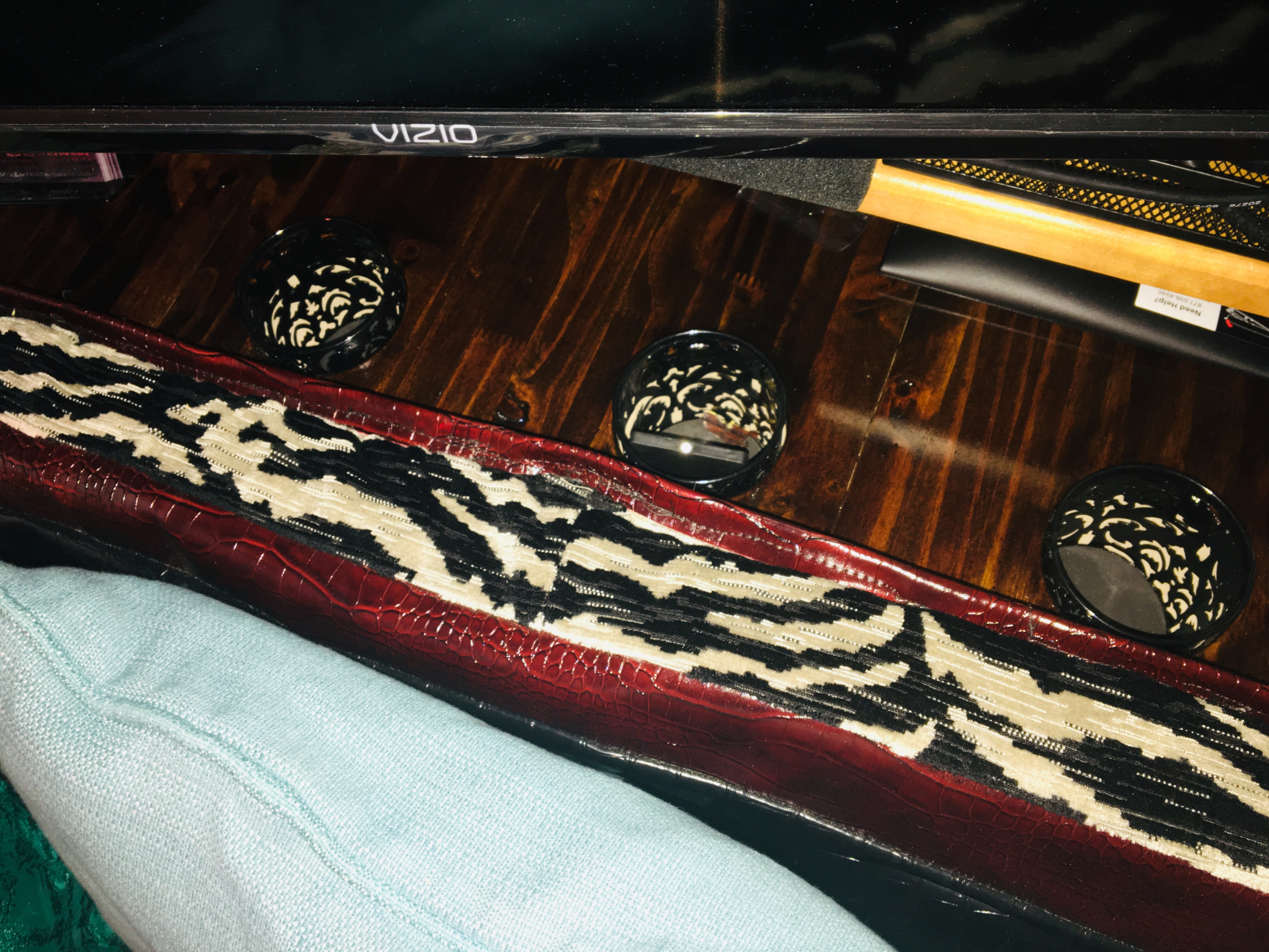 An RV rental's cozy living space with a Vizio TV, a red crocodile-textured bolster pillow, and dark patterned decorative bowls.. Eagle International Tour Bus /w Driver 1985