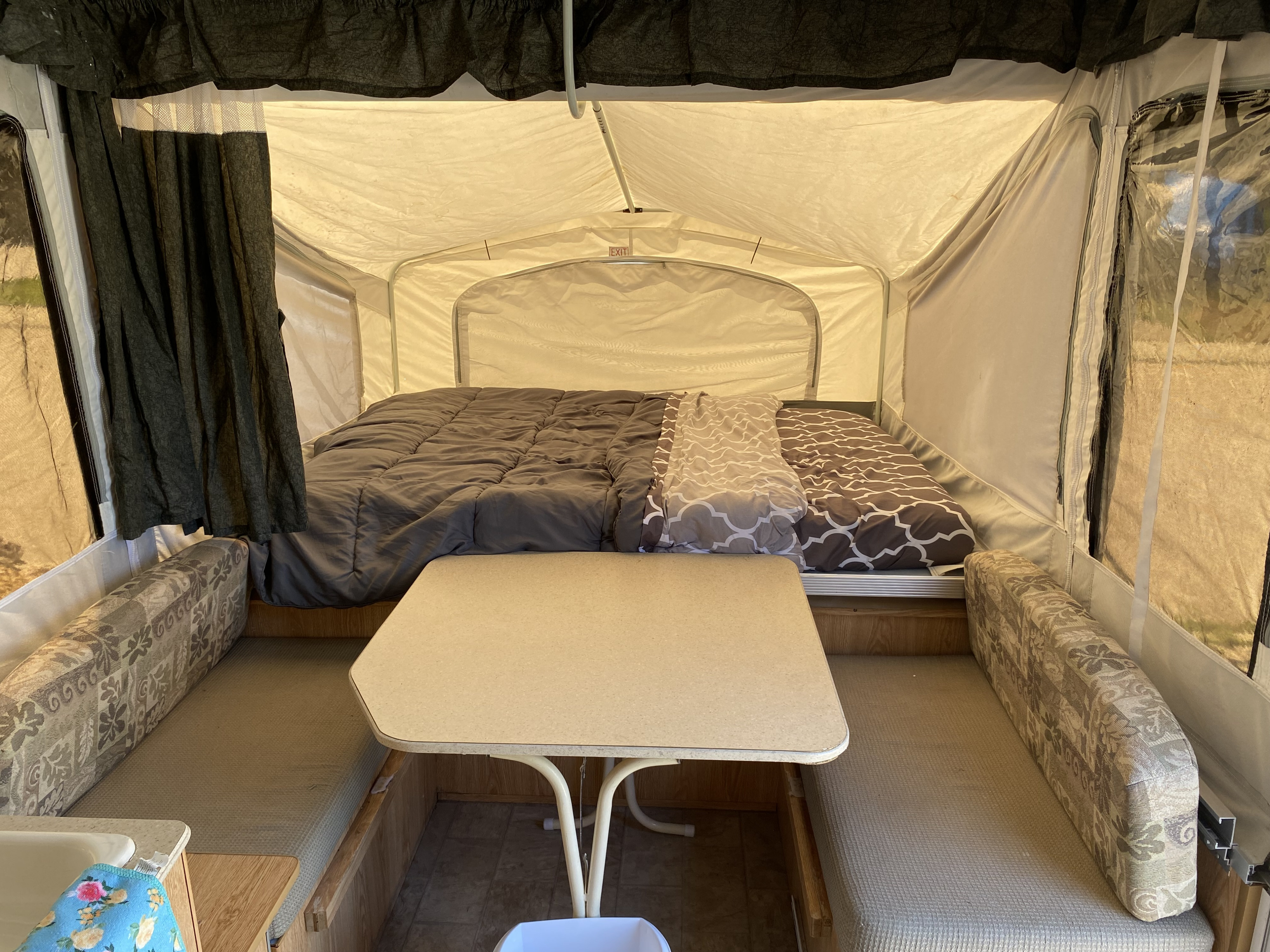 Spacious RV rental pop-up camper interior featuring comfortable beds, a central dinette, and tent-like walls.. Palomino Yearling 2012