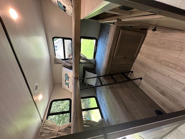 Spacious RV rental bunk room: multiple stacked beds, windows, and wood-look flooring for cozy stays.. Forest River Surveyor Legend 2022