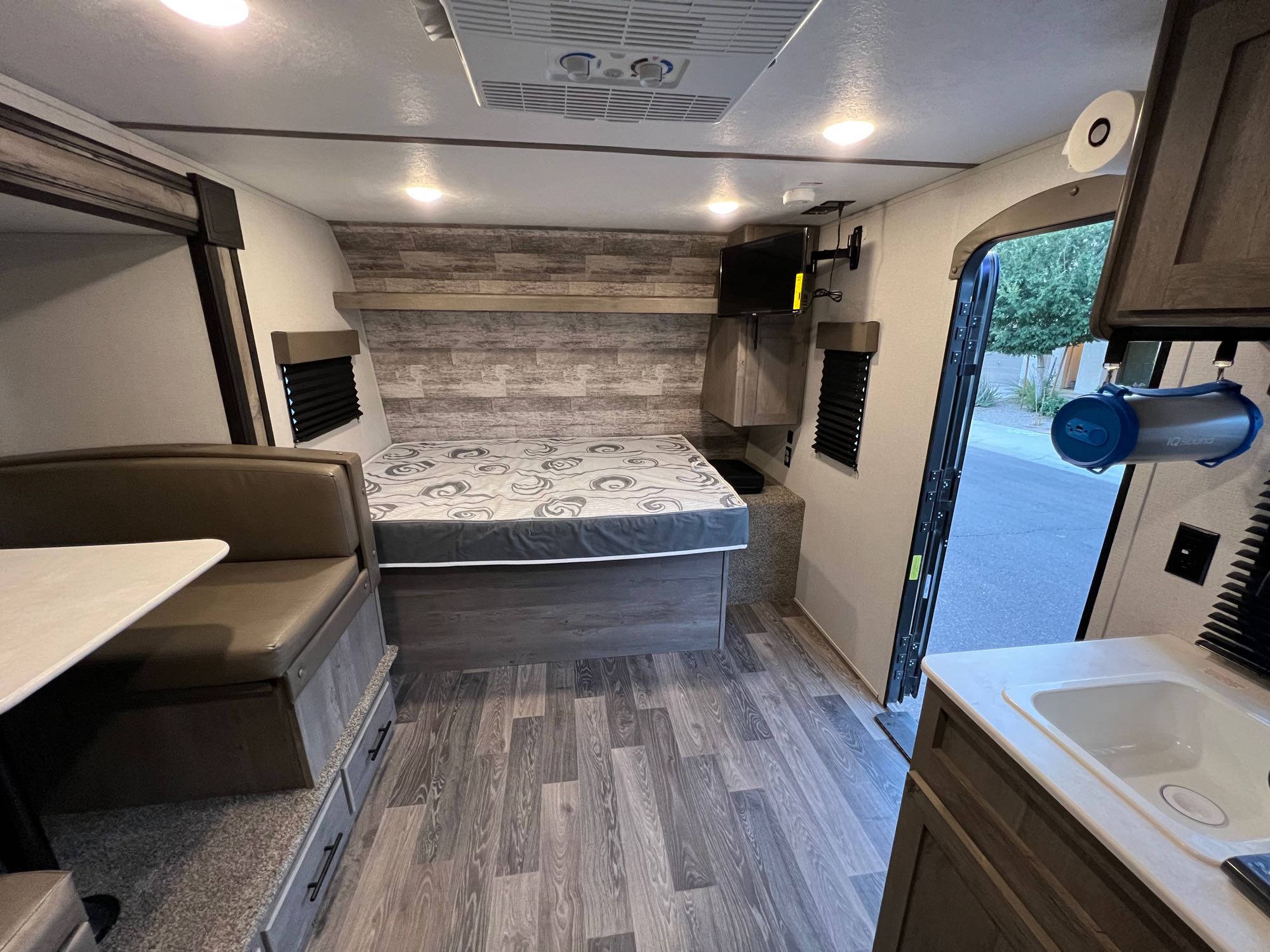 RV rental interior shows bed, dinette, kitchen sink, and TV. A comfortable and functional space for travelers.. Keystone RV Springdale 2021