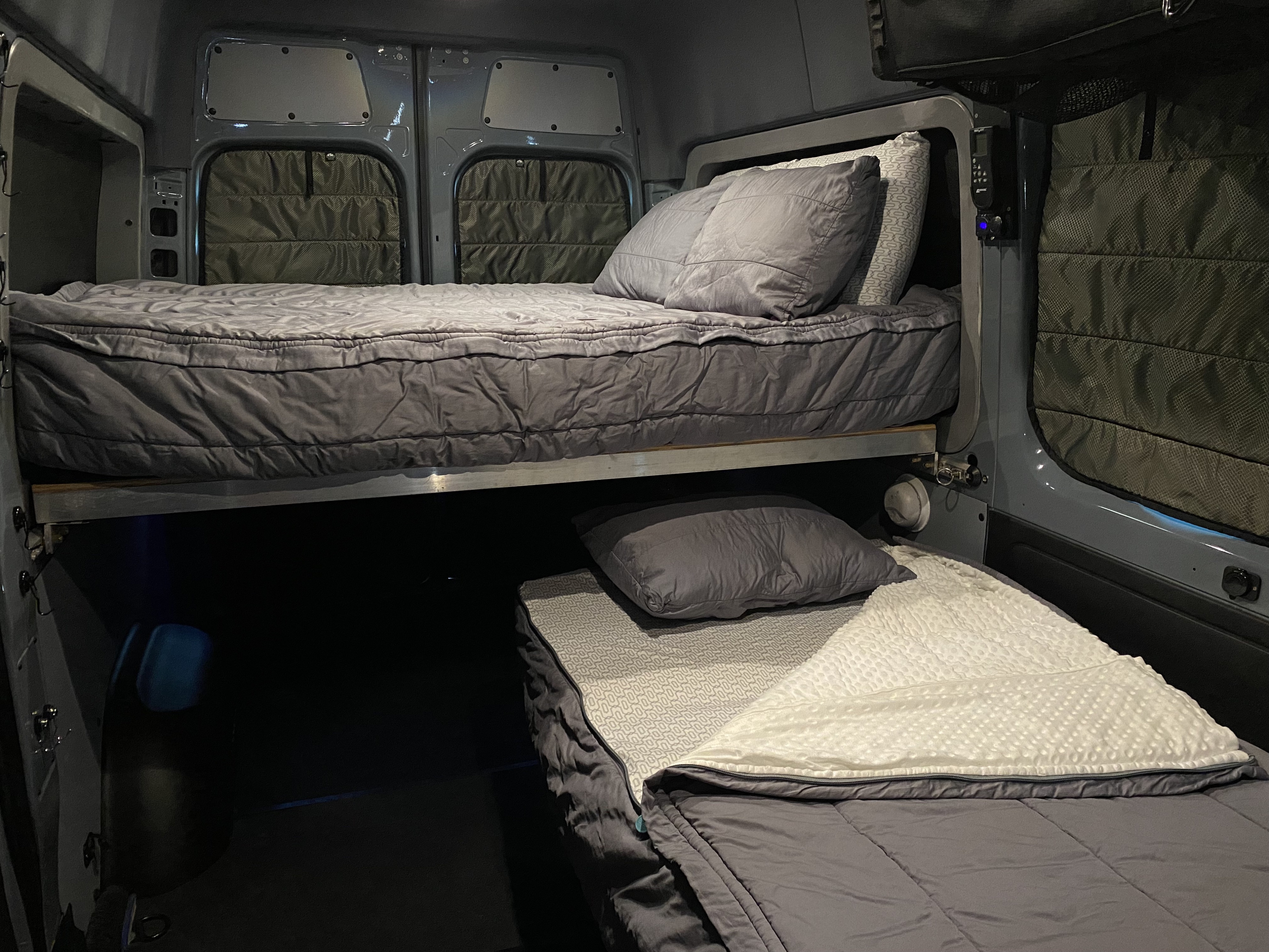 Inside a spacious RV rental: cozy bunk beds with comfy bedding, perfect for mobile adventures.. Mercedes-Benz Sprinter 2019