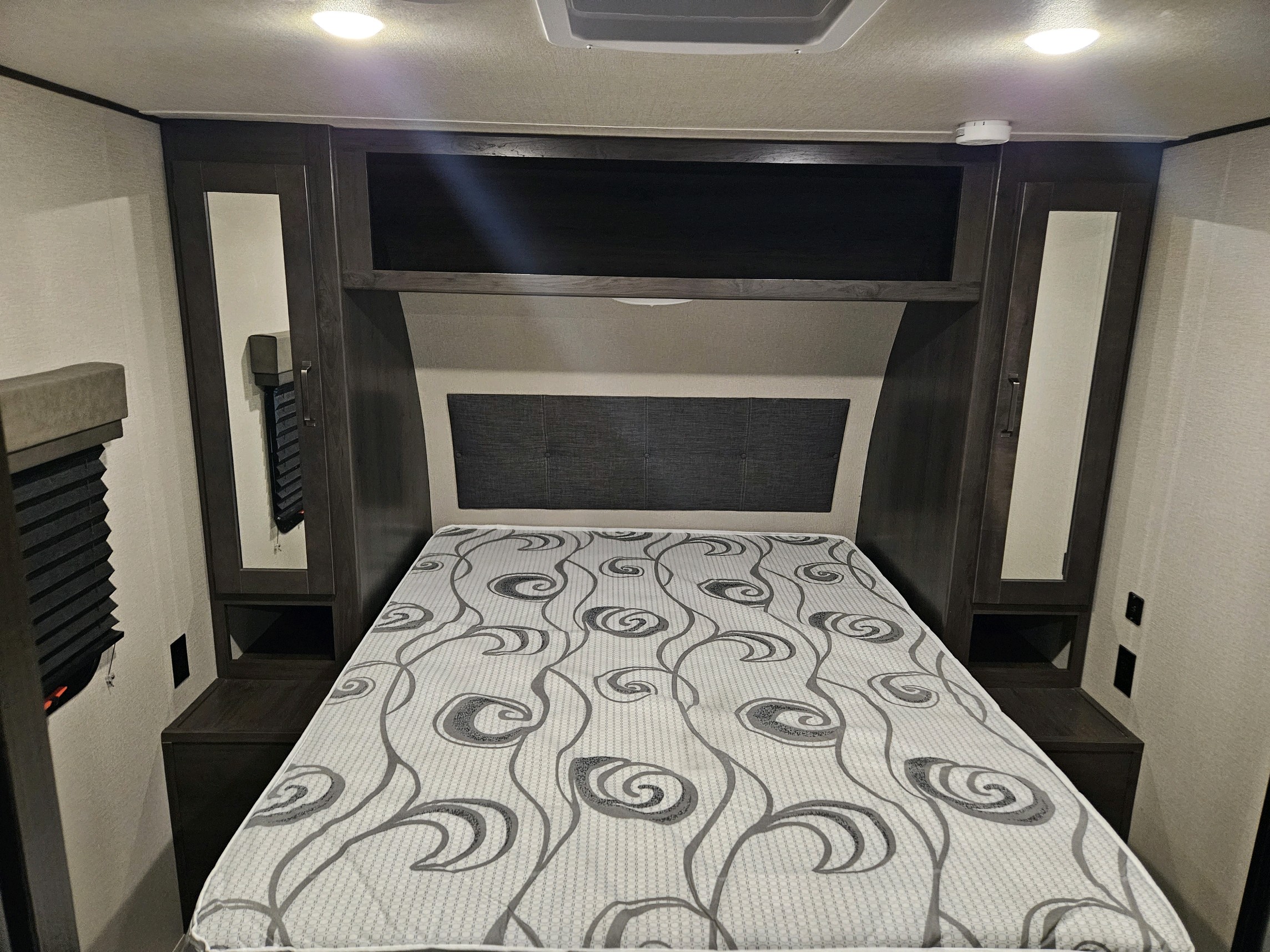 RV rental interior: Bedroom with a comfortable bed, mirrored wardrobes, and convenient outlets.. Grand Design Transcend Xplor 2022