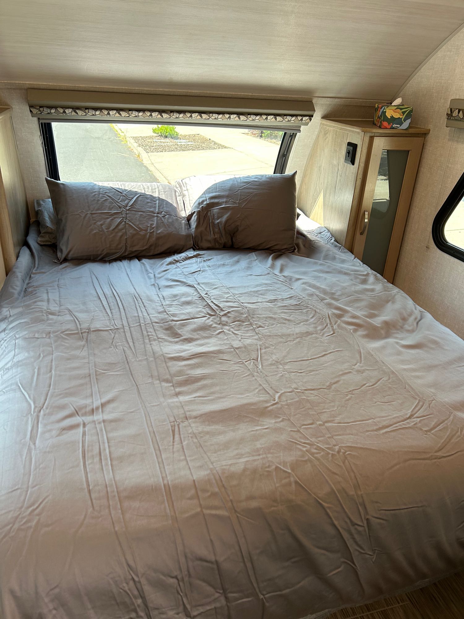 Cozy RV rental bedroom with a full bed, window view, and built-in storage. Perfect for your next adventure!. R-Pod Hood River Edition 2020