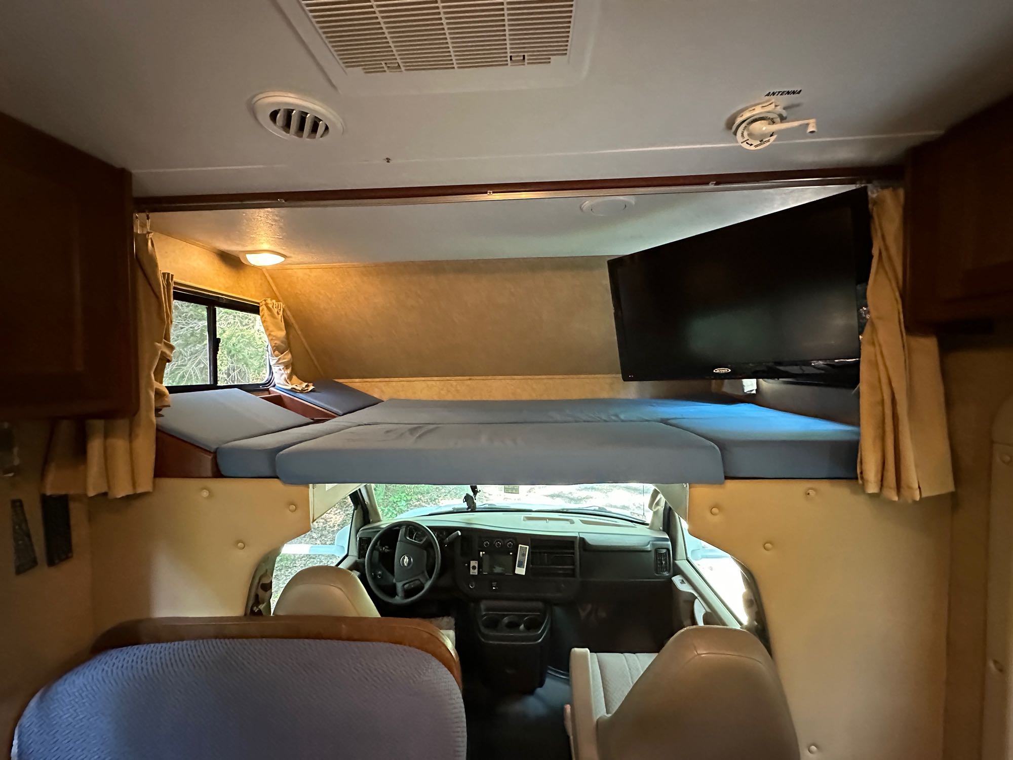 Inside this RV rental: comfortable cab-over bunk, TV, and spacious driver's area for memorable road trips.. Forest River Chevy Express 2014