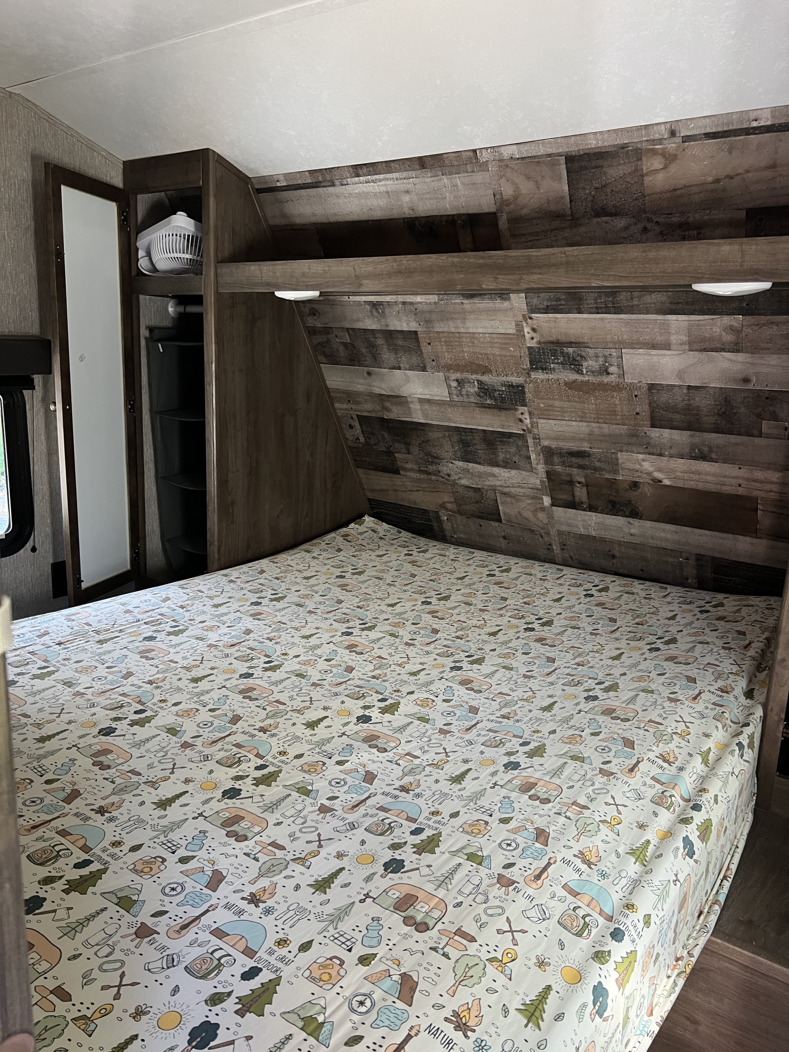 Cozy RV rental bedroom featuring a camping-themed bed and built-in storage, ideal for your next outdoor adventure.. Aspen Trail Aspen Trail Trailer 2020