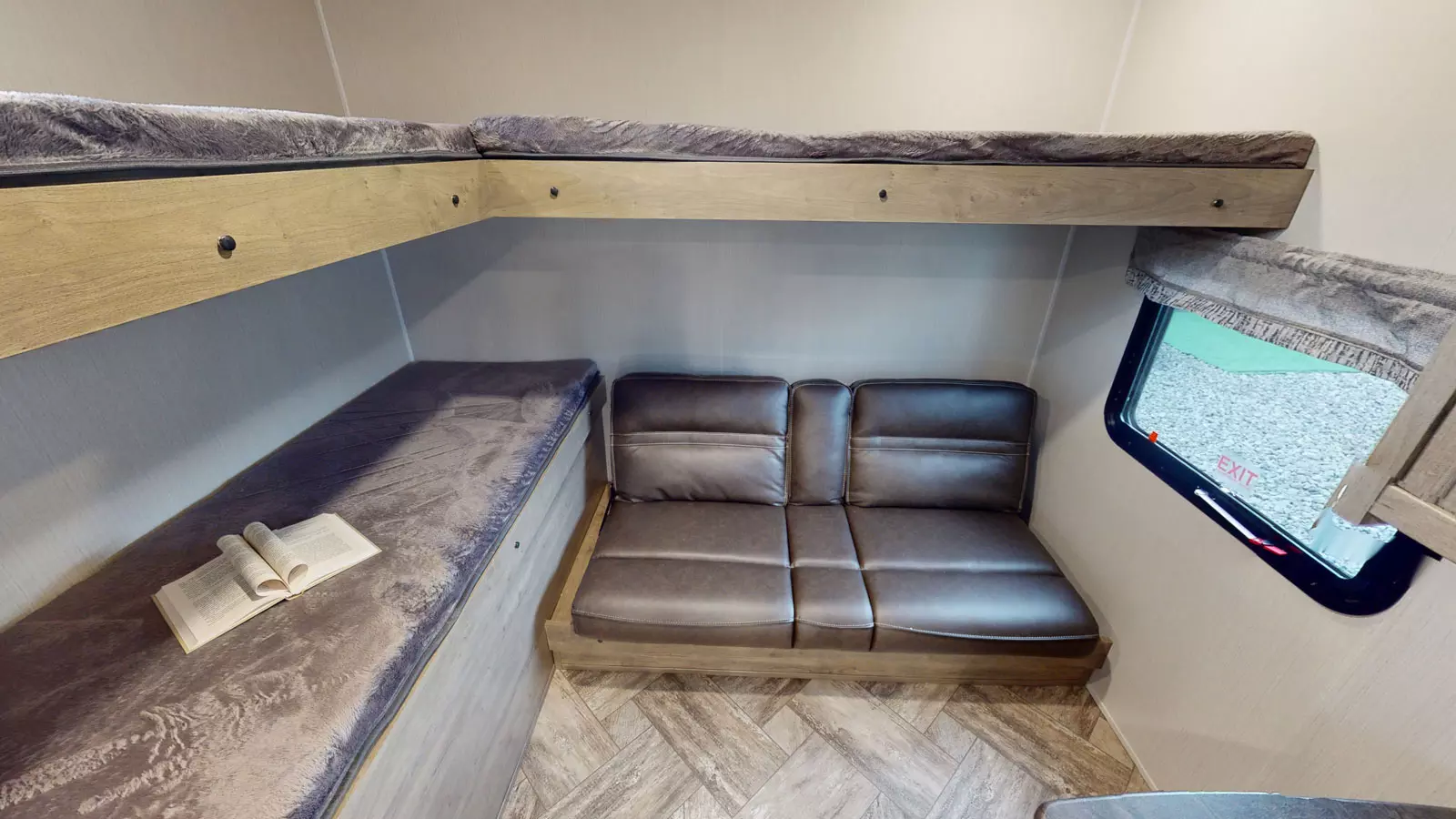 Spacious RV rental sleeping area with an upper bunk bed, lower bed, and a two-seater sofa. Includes an escape window.. Forest River Palomino Puma 2022