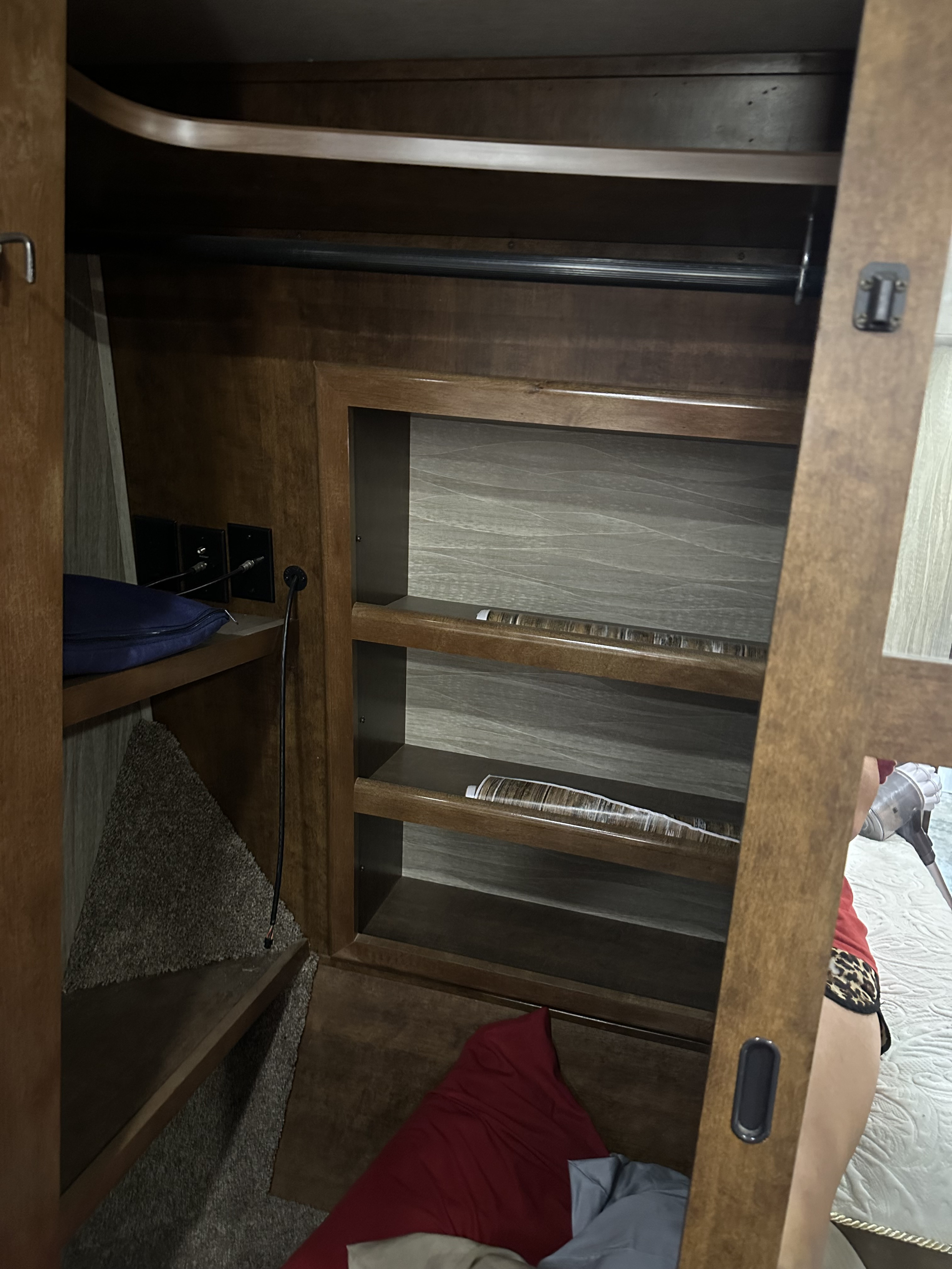 RV rental: Wooden wardrobe interior with hanging rod, shelves, and electrical outlets for storage and power.. Heartland RVs Big Country 2018
