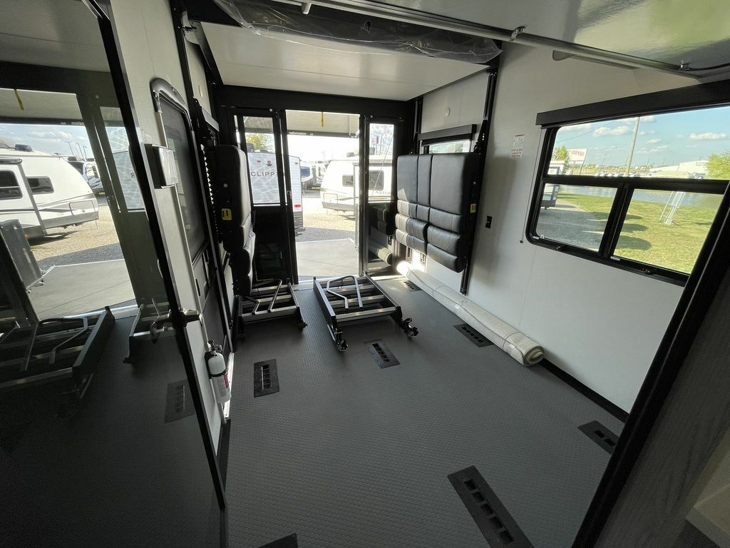 This RV rental's toy hauler garage features fold-up padded seating/beds, durable flooring, and large windows.. Keystone Fuzion 2021