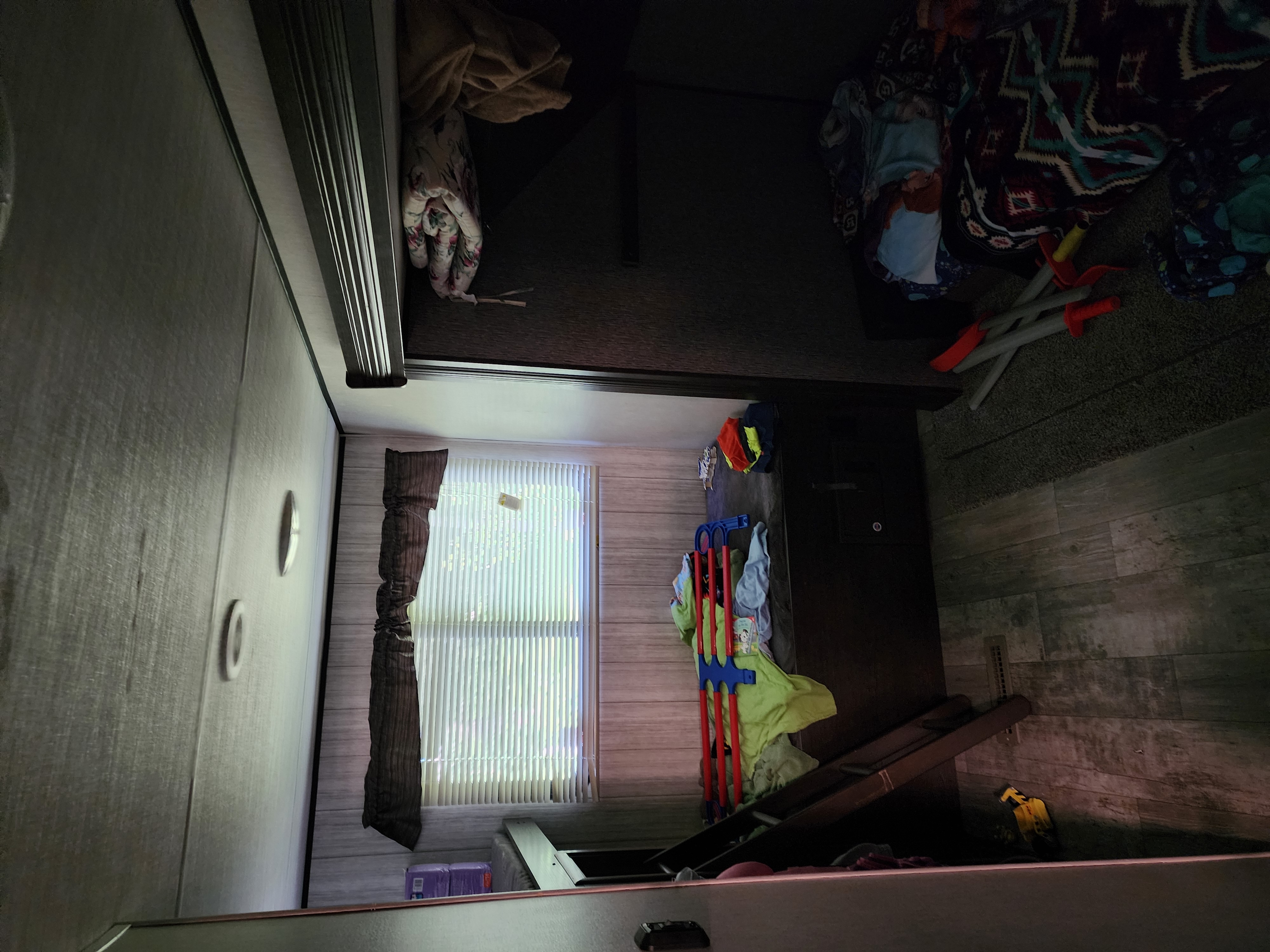 An RV rental interior, revealing a snug space with bunk beds, a window, and various personal items. Accessible for all.. Heartland RVs Pioneer 2020