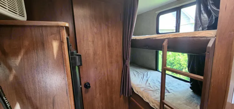 Cozy RV rental interior featuring compact bunk beds with a ladder and bright windows.. Jayco Jay Feather 2017