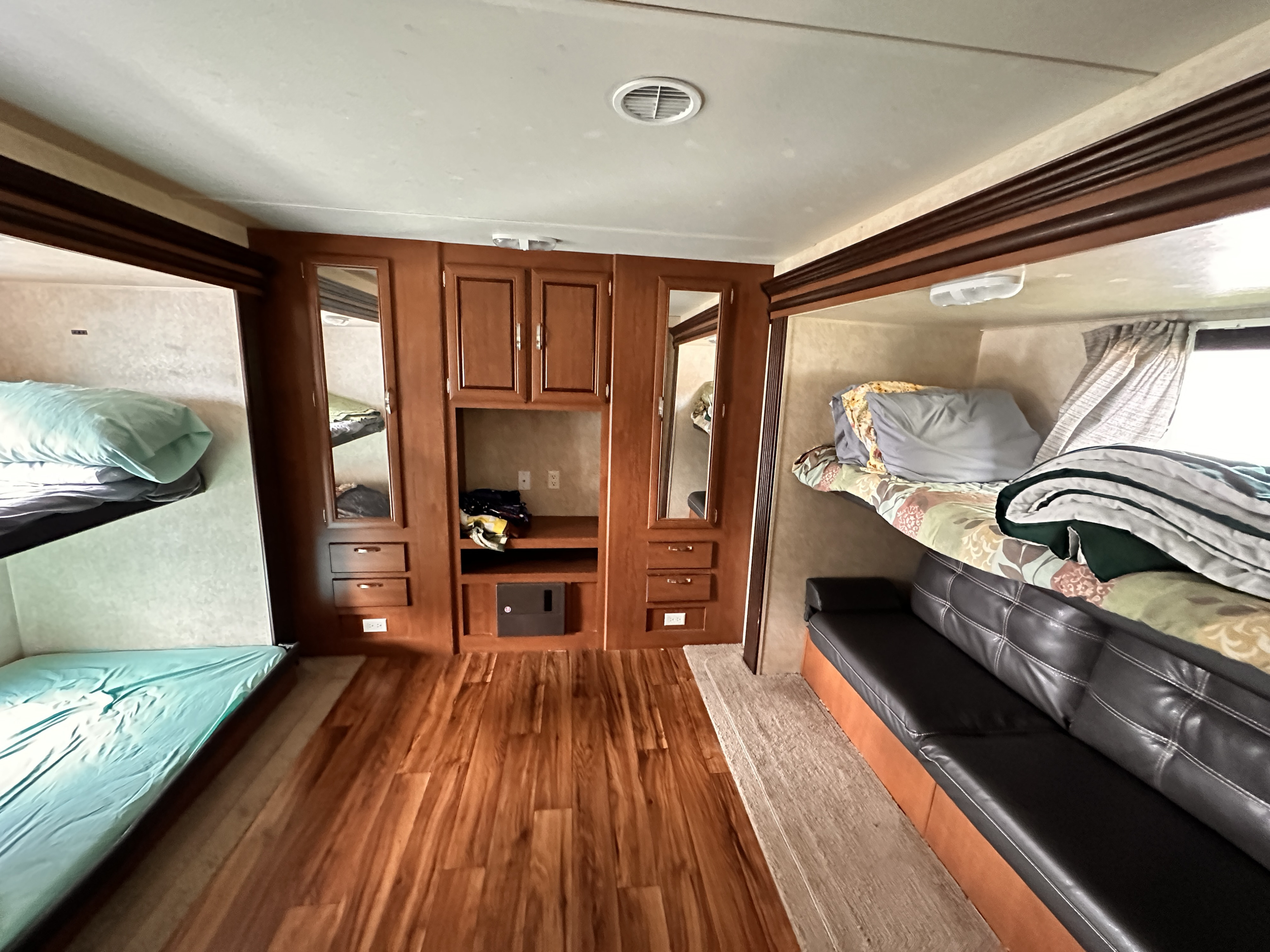 RV rental interior: cozy, functional space with bunk beds, sofa, wood cabinets, and laminate flooring for comfortable travel.. Forest River Salem 2016