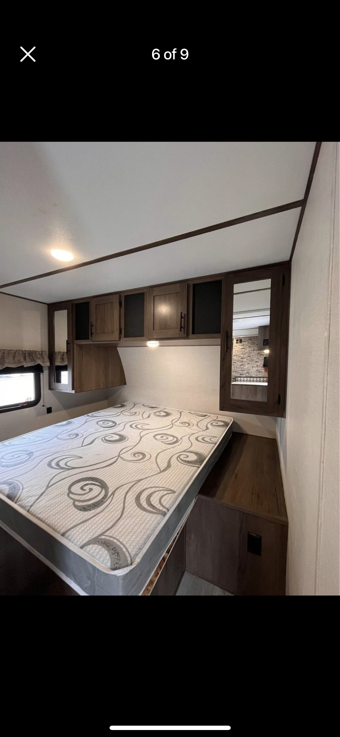 Cozy RV rental bedroom featuring a patterned mattress, overhead cabinets, and a window. Ideal for travel accommodation.. Primetime Avenger 26bh 2020