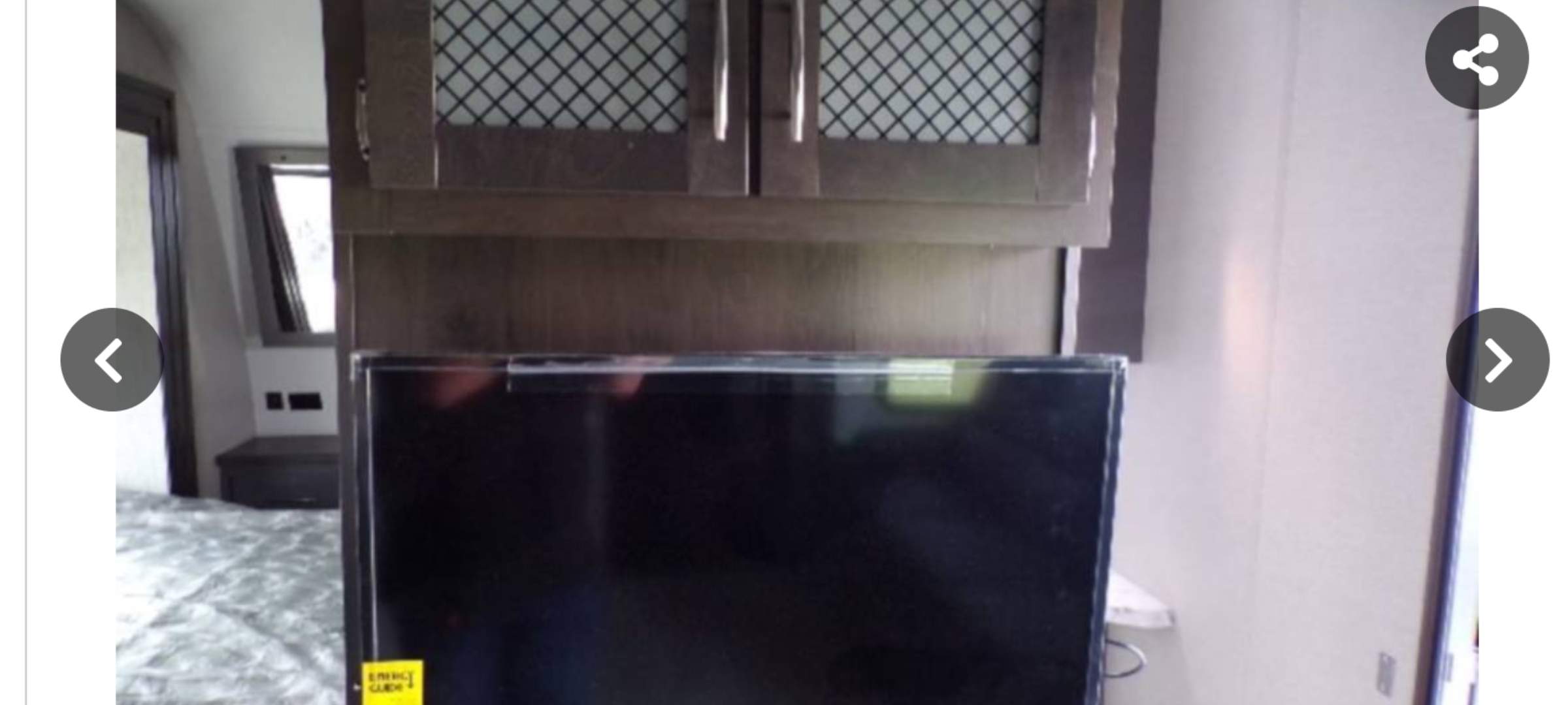 RV rental interior: cozy bedroom with TV, overhead storage, and comfortable bedding in a modern travel trailer.. Grand Design Momentum 2022