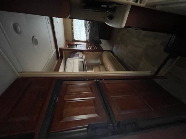 RV rental interior: A long view of the RV's living space, featuring dark wood cabinets, dinette, and a sleeping area. Compact design.. Forest River Forester 317DS 2014