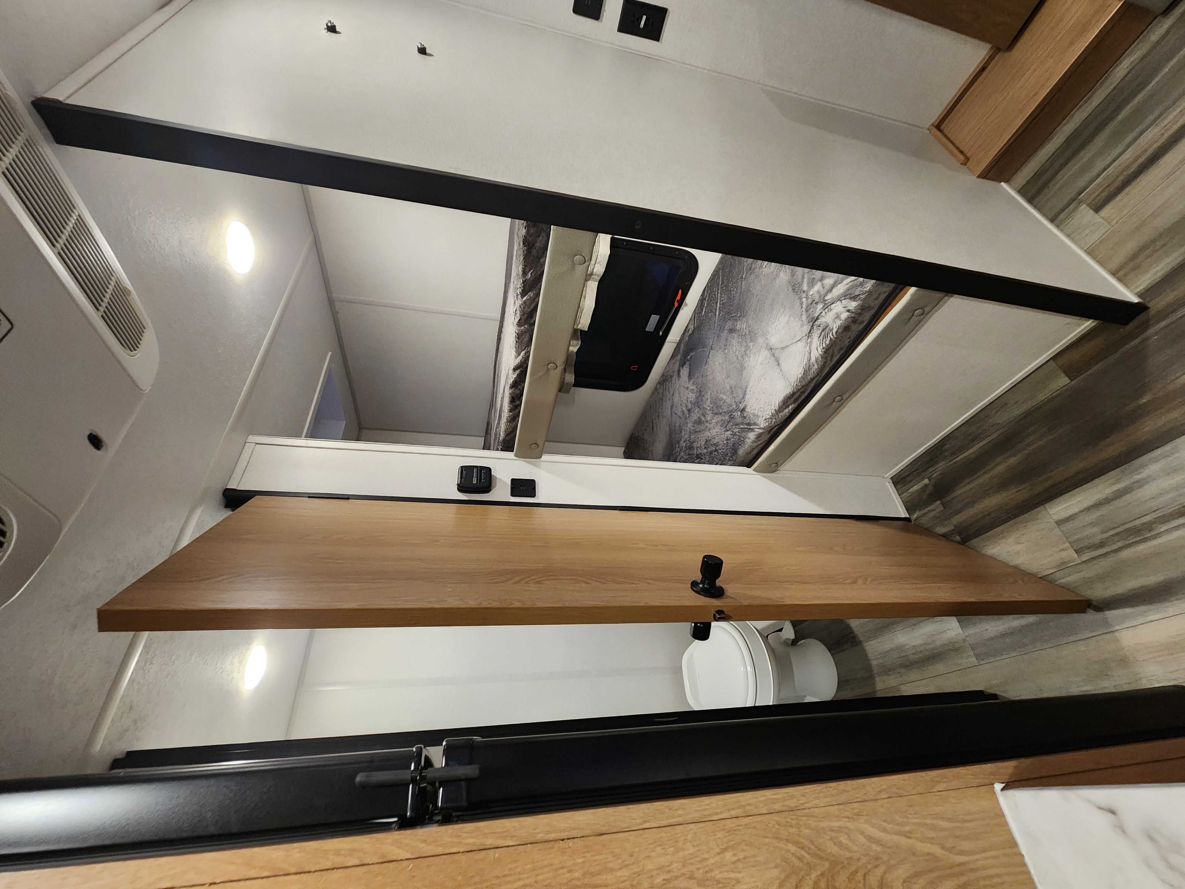 This compact rv rental interior features bunk beds, a toilet area, AC unit, and wooden counter, optimizing space for travelers.. Avenger LT 2022