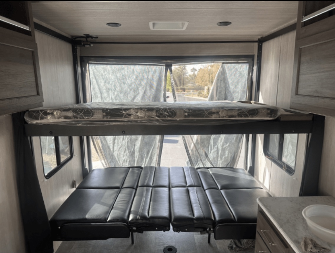 RV rental interior: A top bunk bed & lower convertible sofa, with screened windows, offers versatile sleeping options.. Genesis Supreme Rv Powerlite Prime 1915 2022