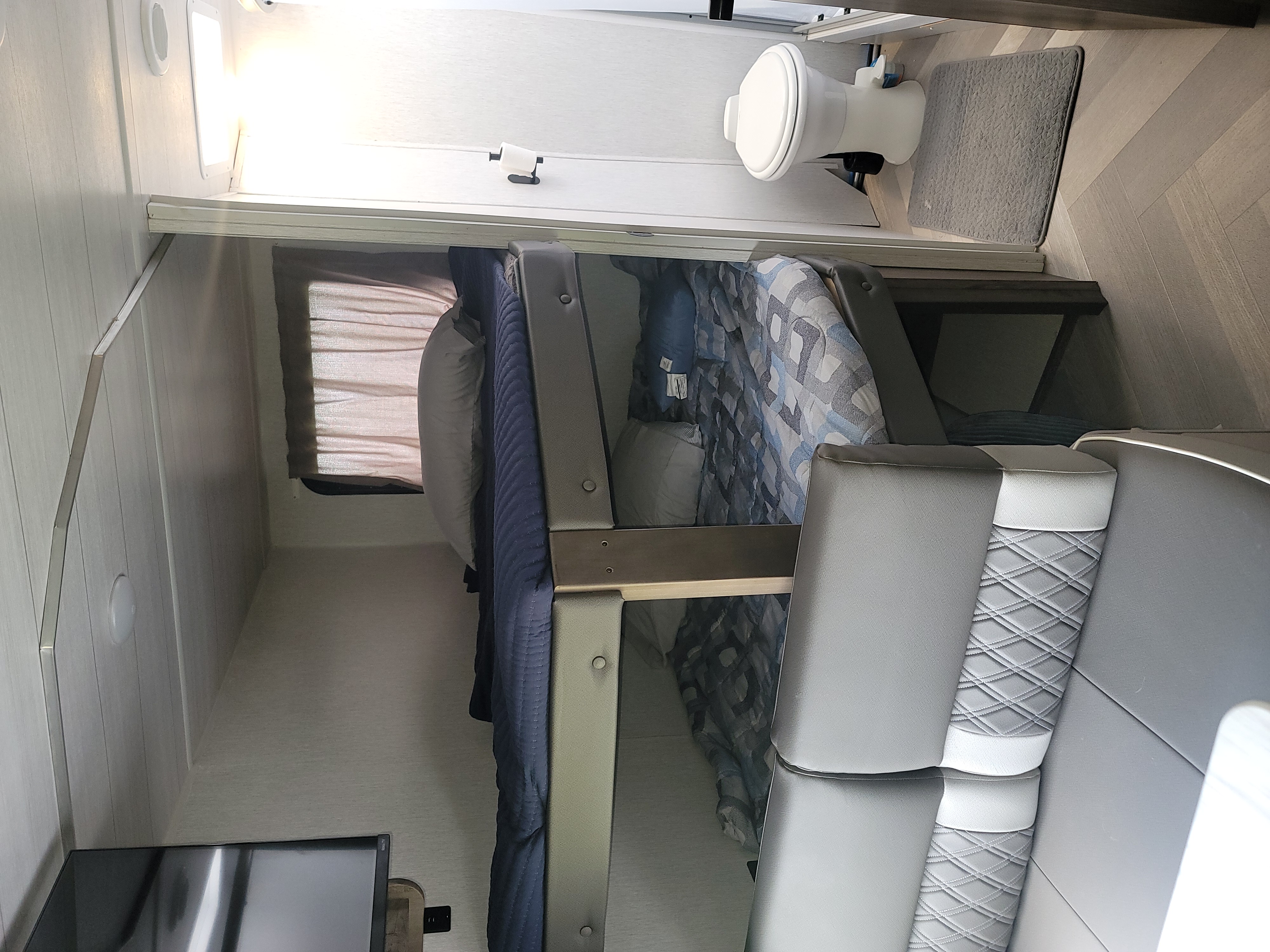 RV rental interior featuring bunk beds, a compact bathroom with a toilet, and a functional dinette seating area.. Forest River Salem Cruise Lite 2022
