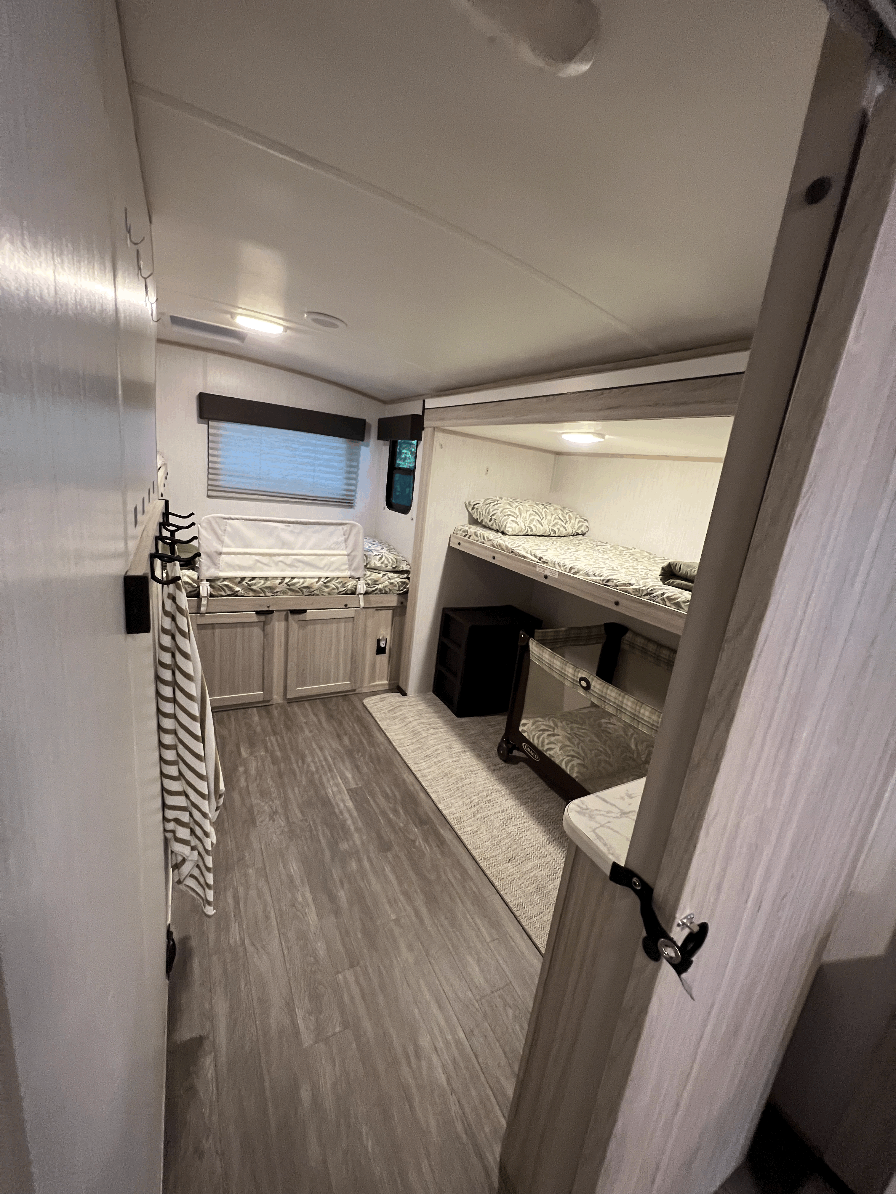 Step into this comfortable RV rental bunk room, featuring multiple beds, a small playard, and ample storage.. Shadow Trailers shadow cruiser 2022