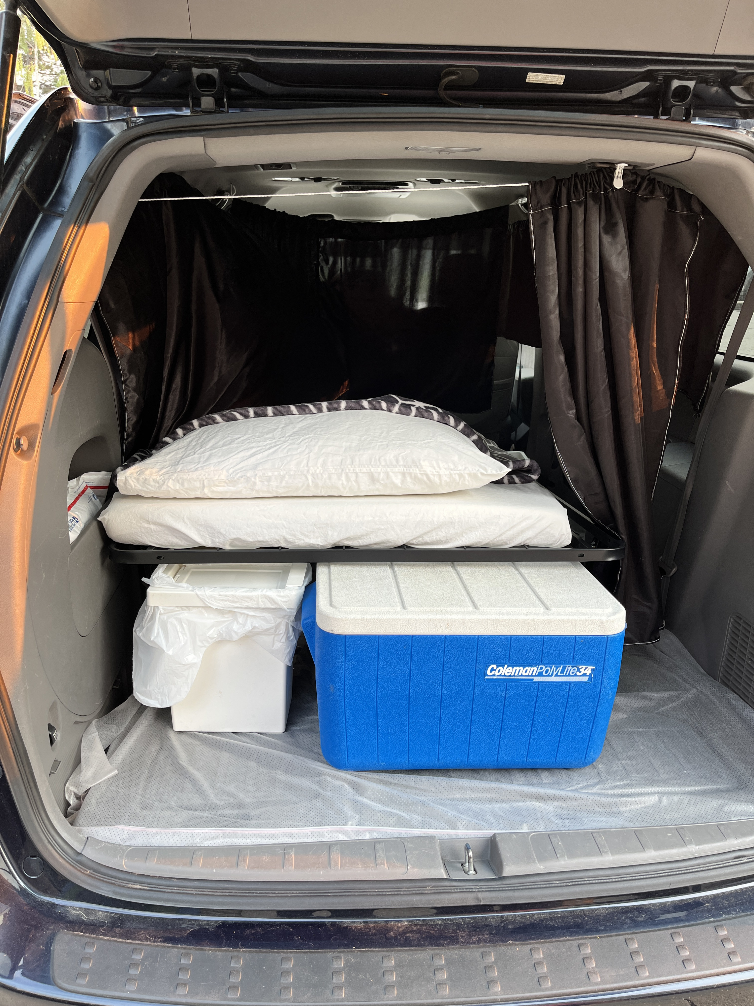 Car camping setup in an SUV/van: bed with privacy curtains, cooler, and storage. Great for an rv rental trip.. Honda Odyssey 2010