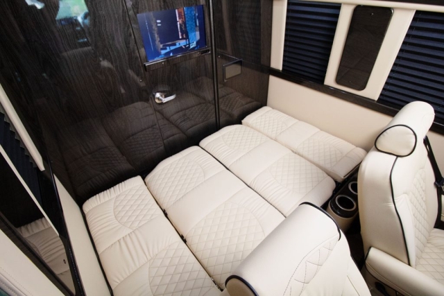 Luxury rv rental interior with a white quilted modular bed and comfortable captain's chairs for your journey.. Ultimate Toys Ultimate Coach 2024