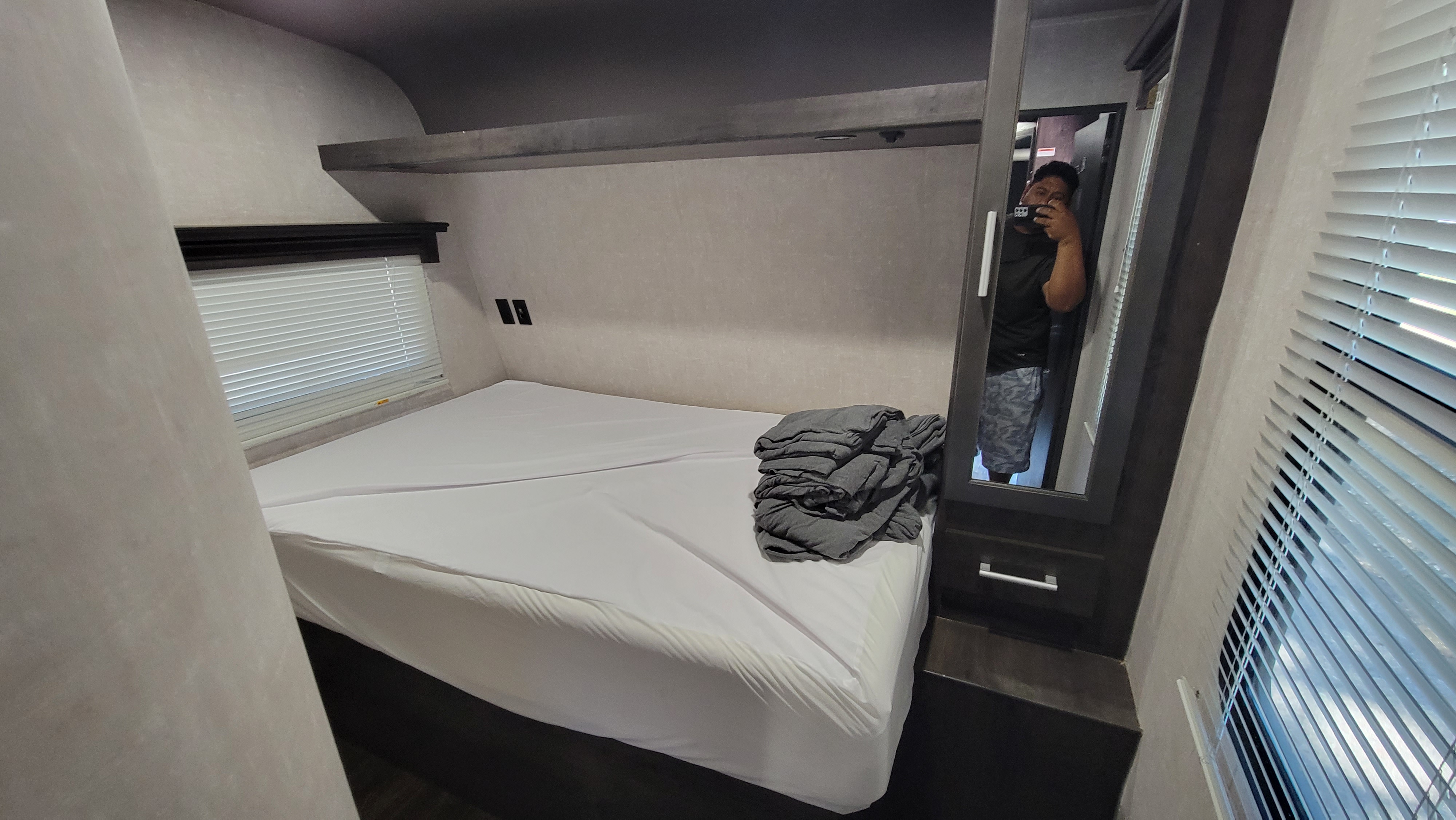 This RV rental bedroom features a queen bed, overhead storage, a window with blinds, and a mirrored closet.. Eclipse Recreational Vehicles Attitude 2020