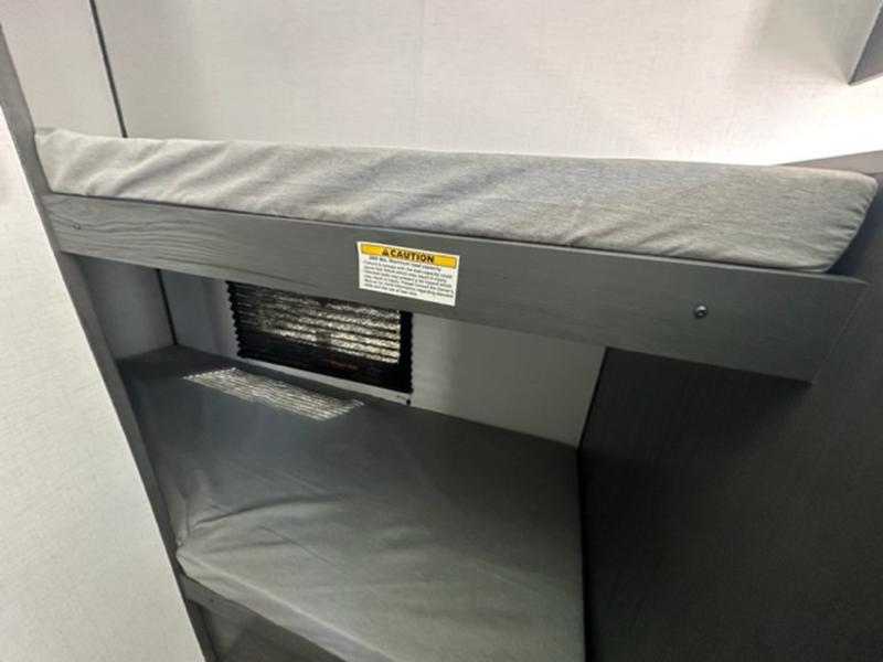 RV rental interior shows cozy gray bunk beds, a compact sleeping area. "CAUTION" sticker on top bunk frame, great for camping.. Aspen Trail 17BH 2023